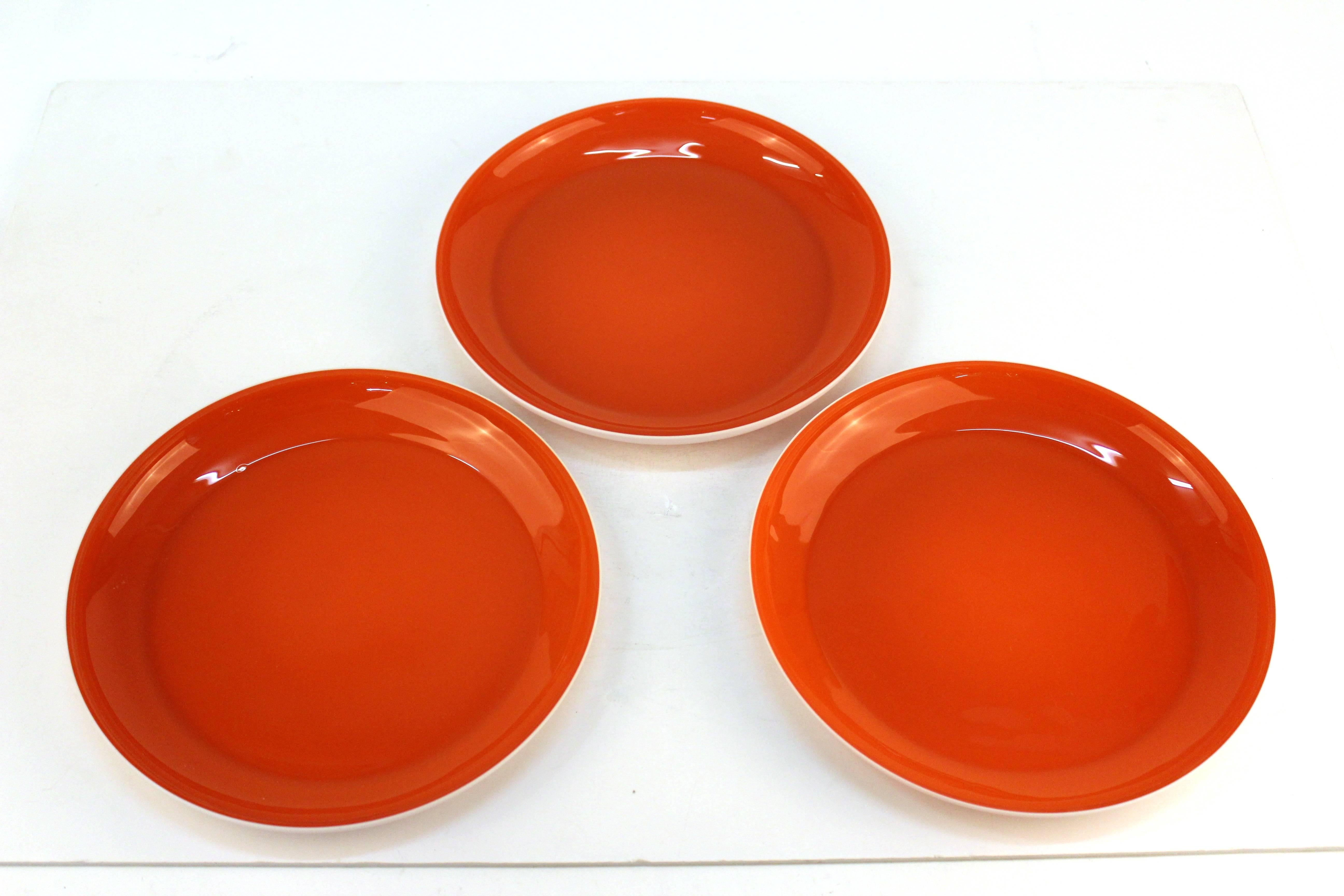 Set of Carlo Moretti plates including eight luncheon plates and three serving plates with bright orange interior and white exterior. Can be purchased as individual sets. See prices below:

Luncheon plate, Set of Eight (1" H x 7" D):