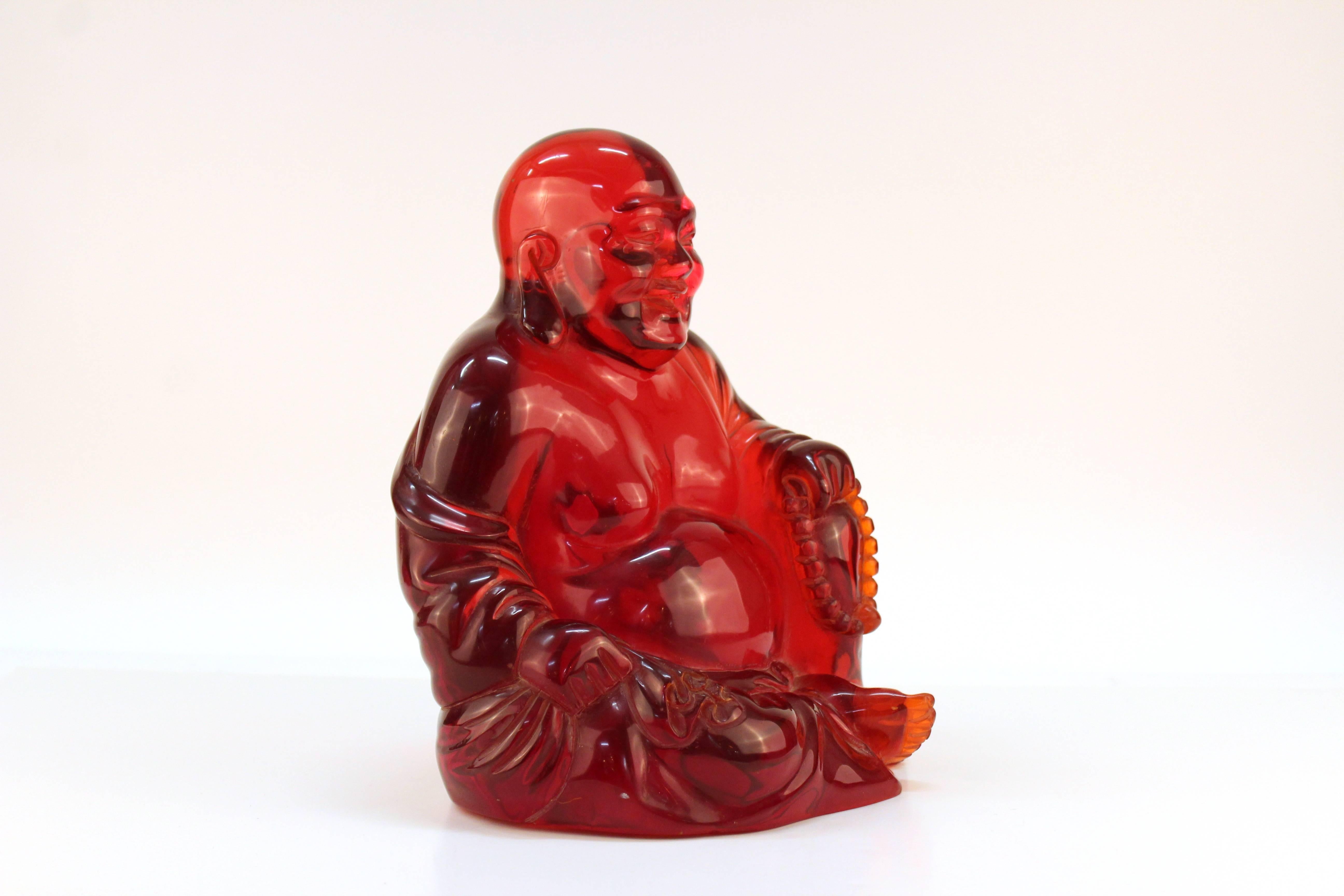 A Mid-Century Modern sculpture of Buddha rendered in translucent bright red resin. In very good condition.