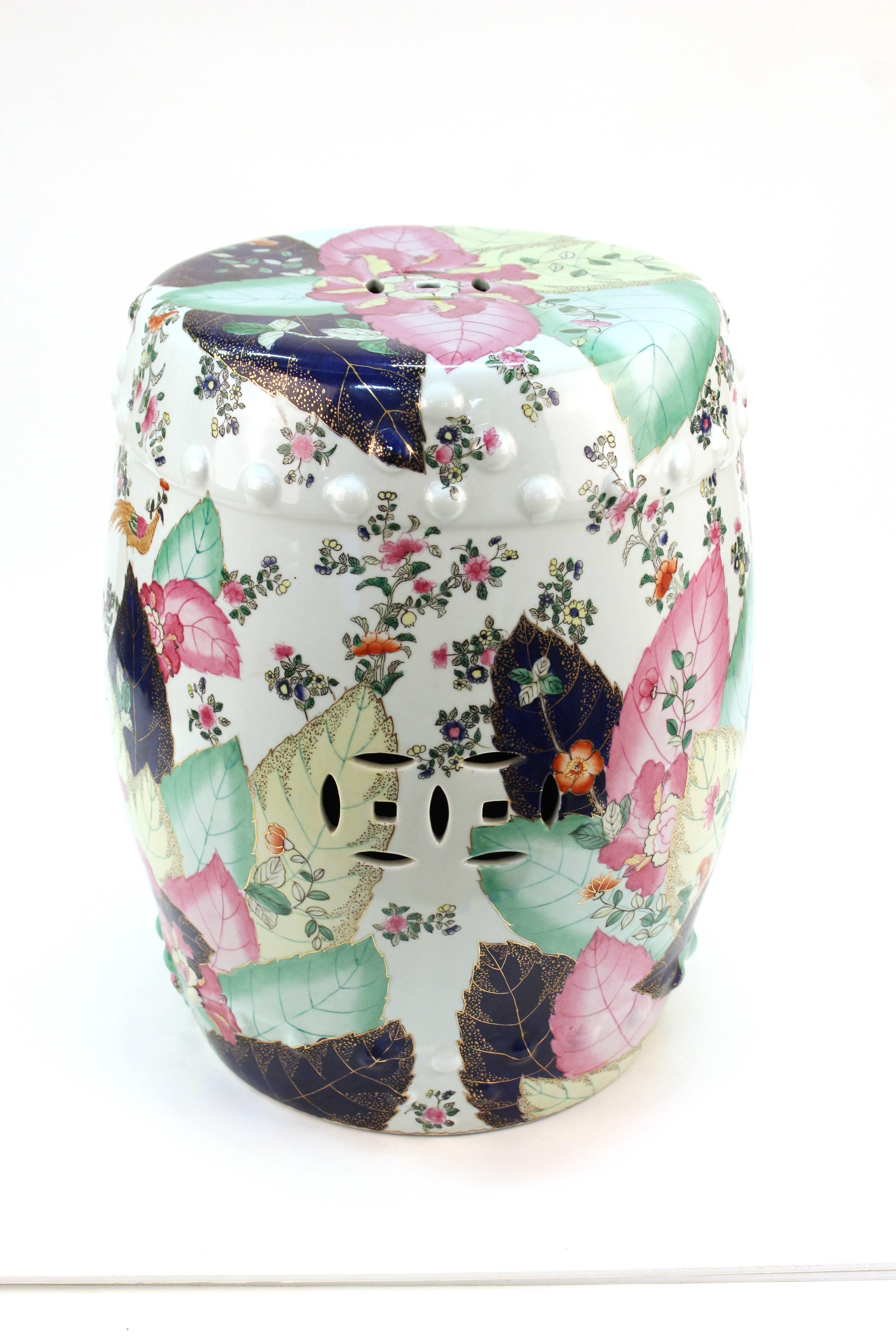 A ceramic garden stool with brightly colored florals and tobacco leaf motif. In very good condition.