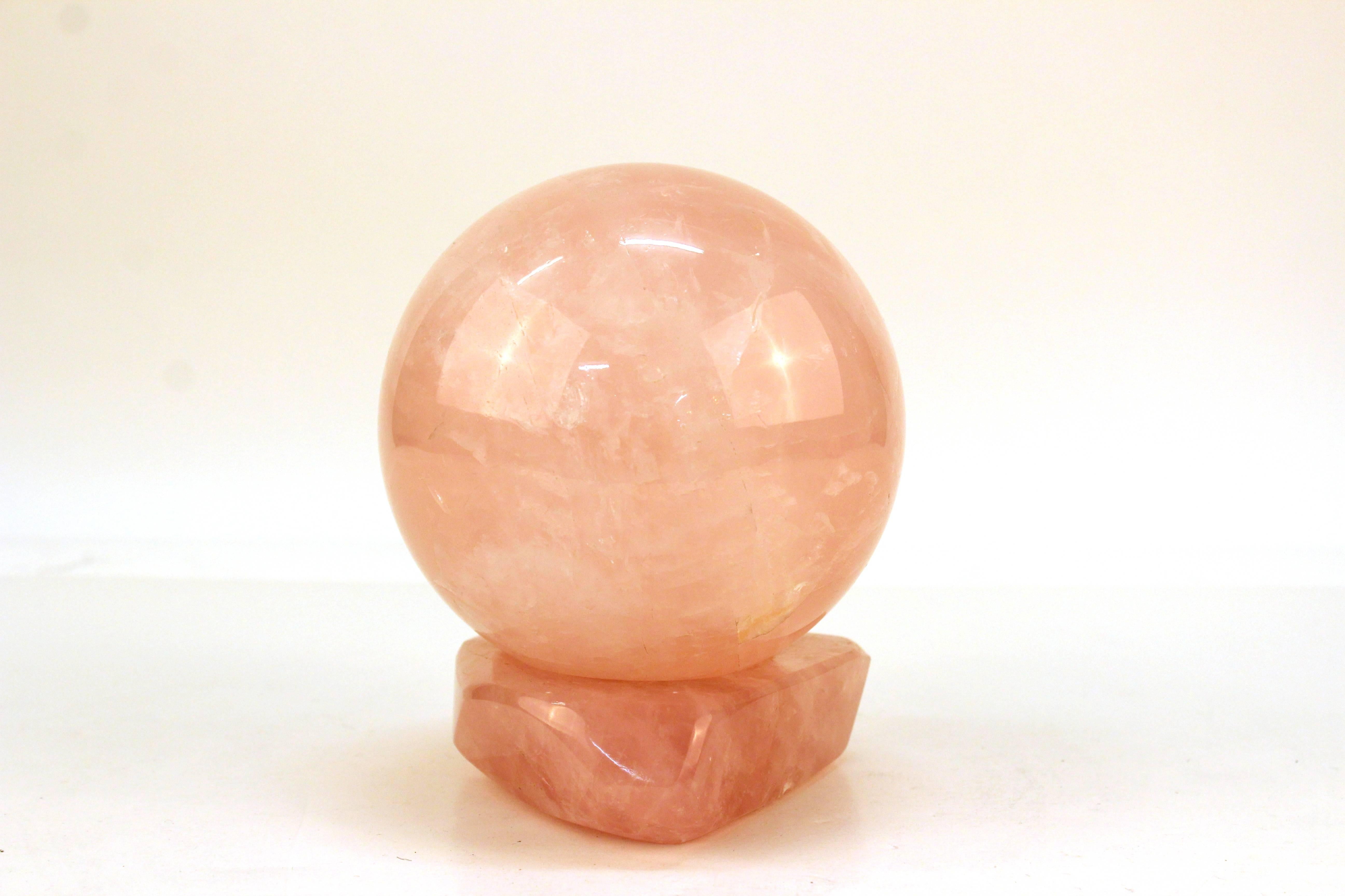 A decorative sphere and stand in matching rose quartz. Both pieces are a deep pink color with highly polished surface. In very good condition.