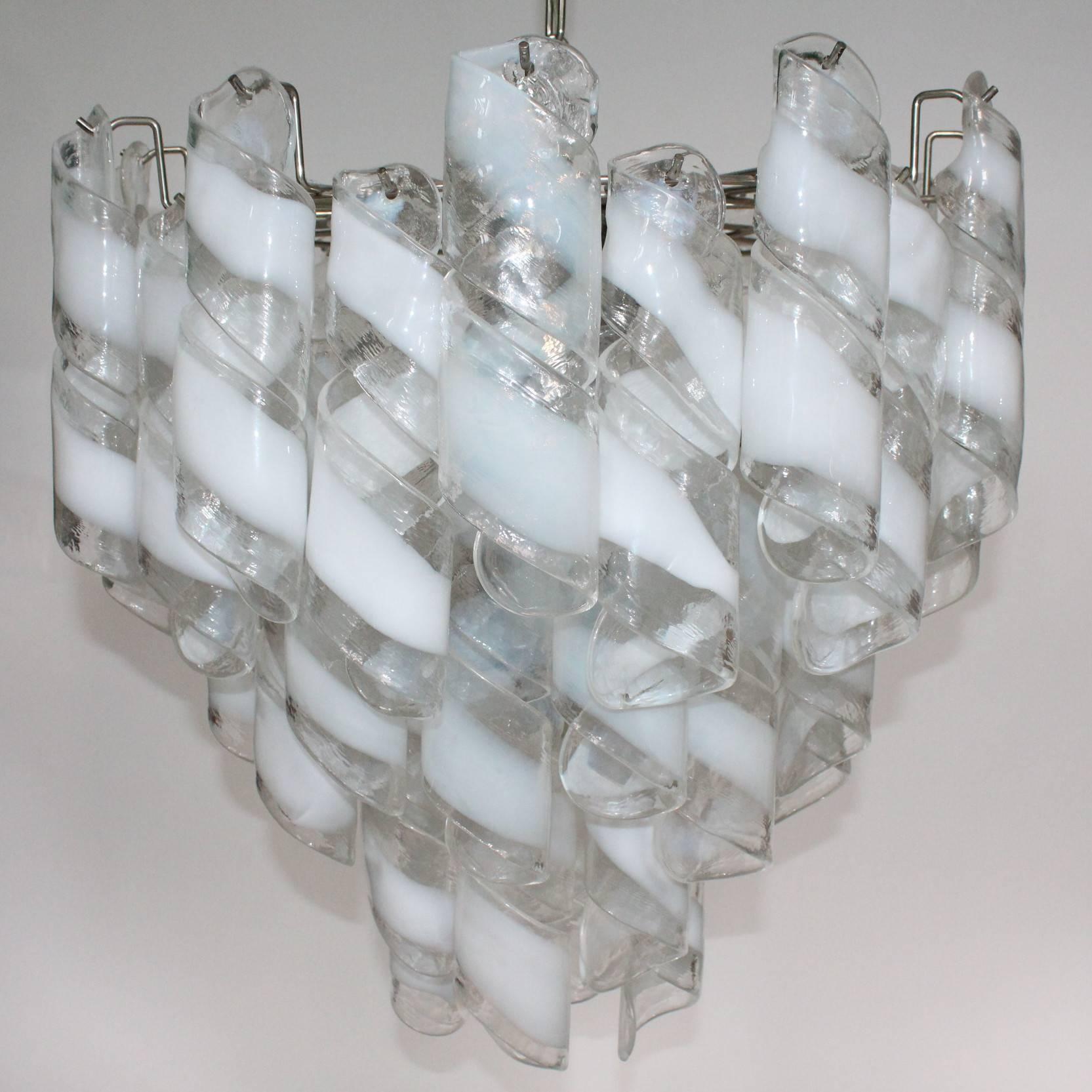 A Murano glass chandelier by Mazzega. Includes tiers of clear and white Murano Glass spiralled ribbons. In good condition.