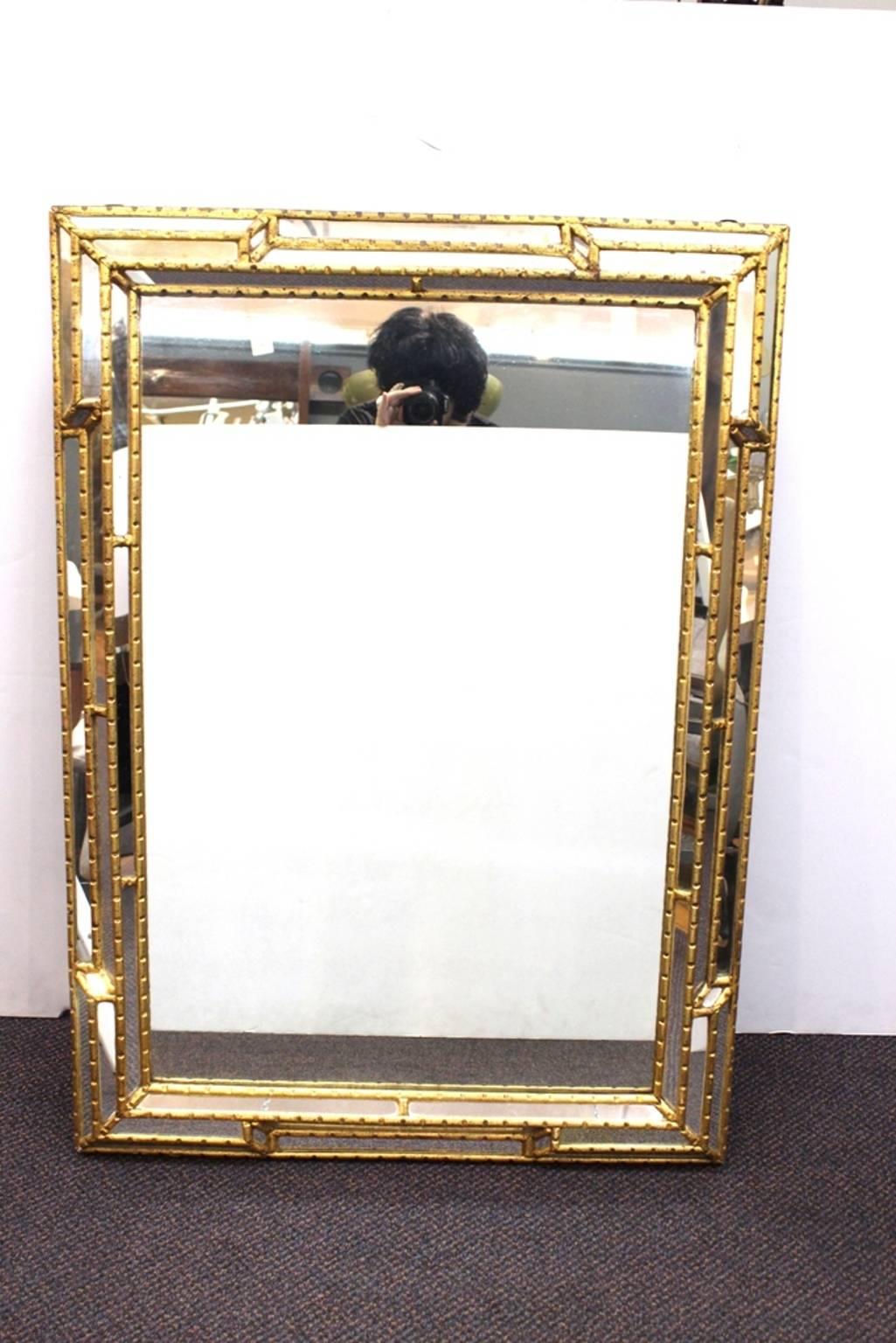 A Venetian mirror in a bevelled gilt frame. Stamped [Made in Italy] on the back. In good condition.