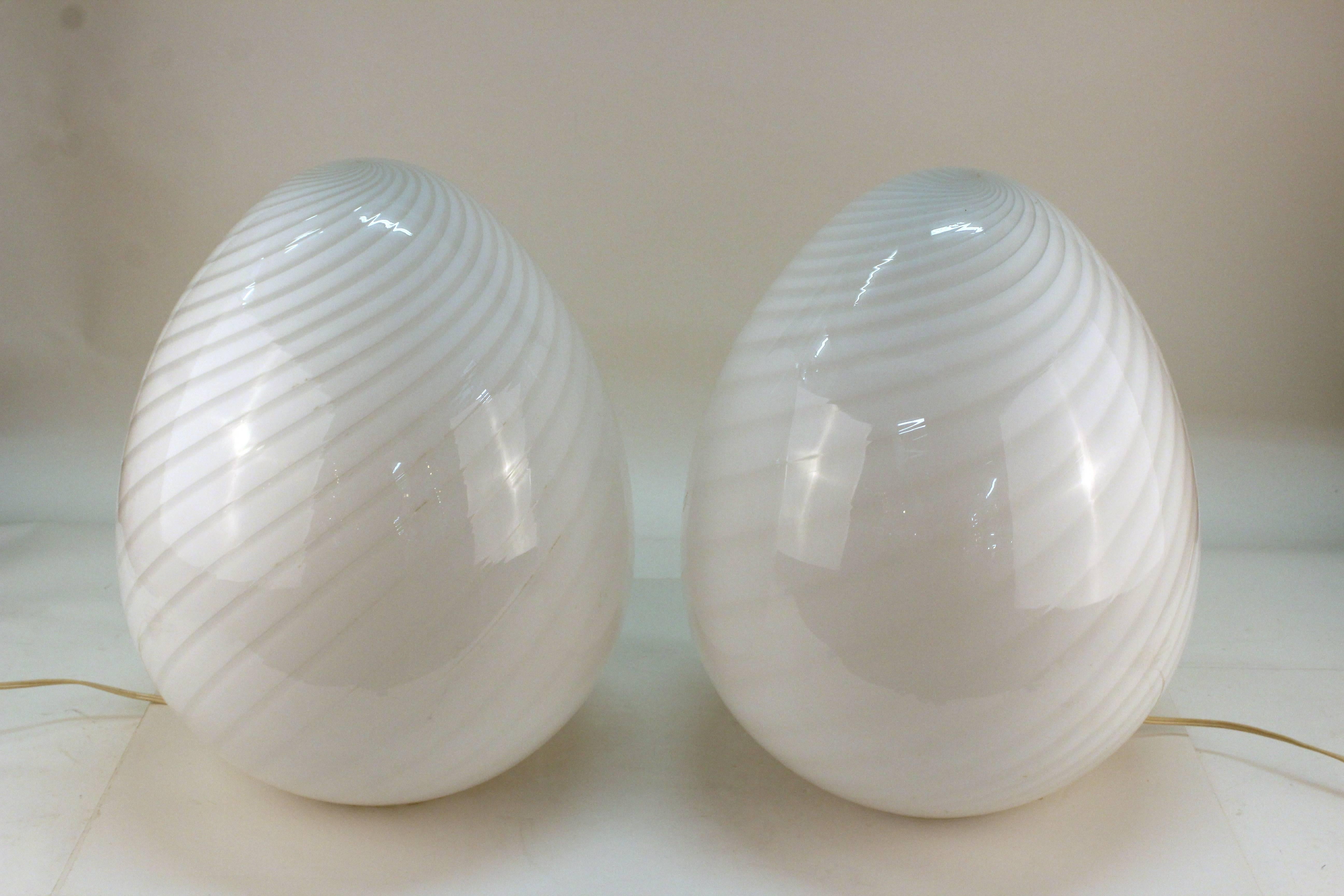 Pair of white swirled blown glass egg lamps. Produced on the Isle of Murano. Both are in excellent condition.
