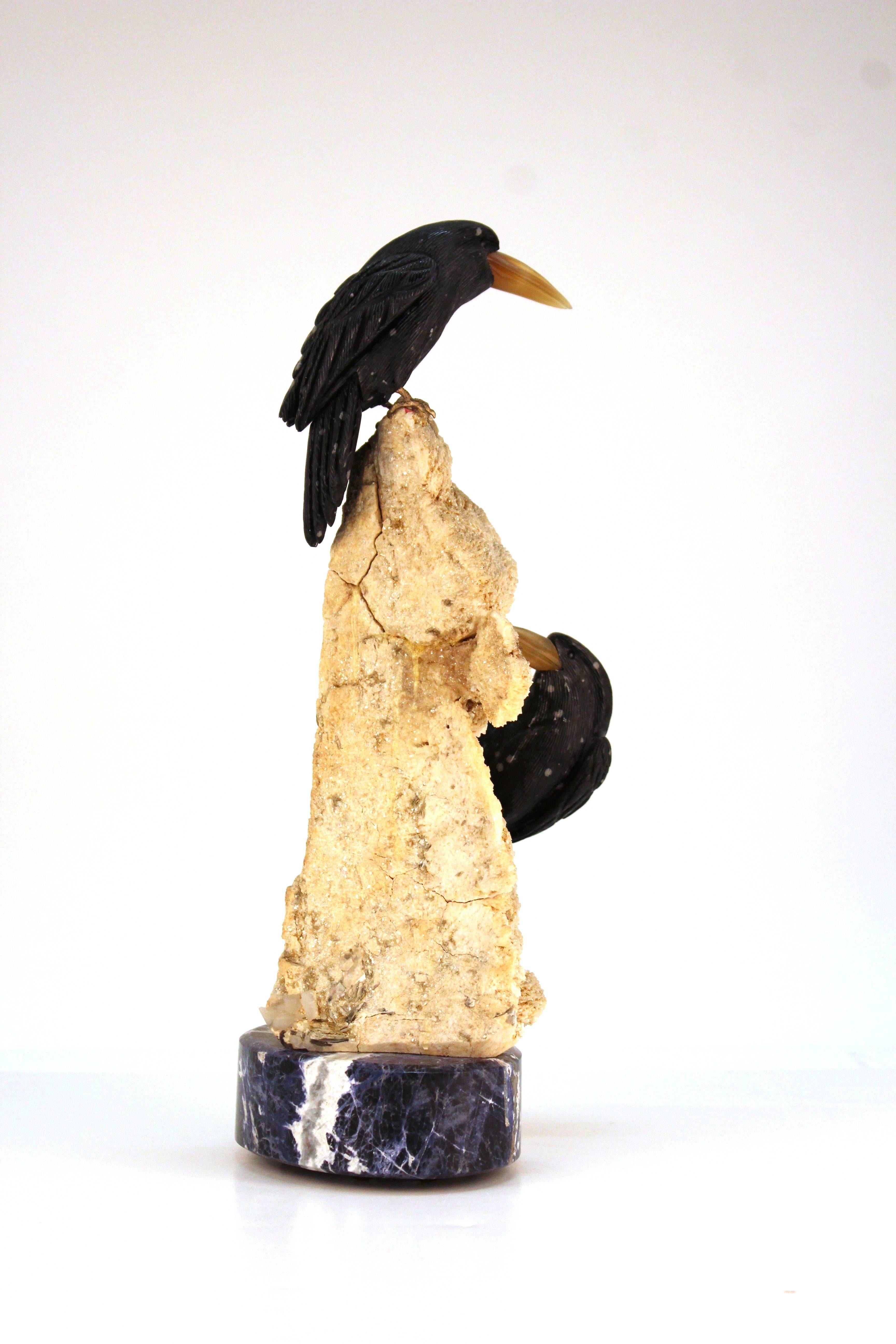 A sculpture made from a bone colored rock crystal. Includes two detailed birds carved from black stone. Mounted on a blue marble base. Despite some wear appropriate to material and use the piece is in good condition.