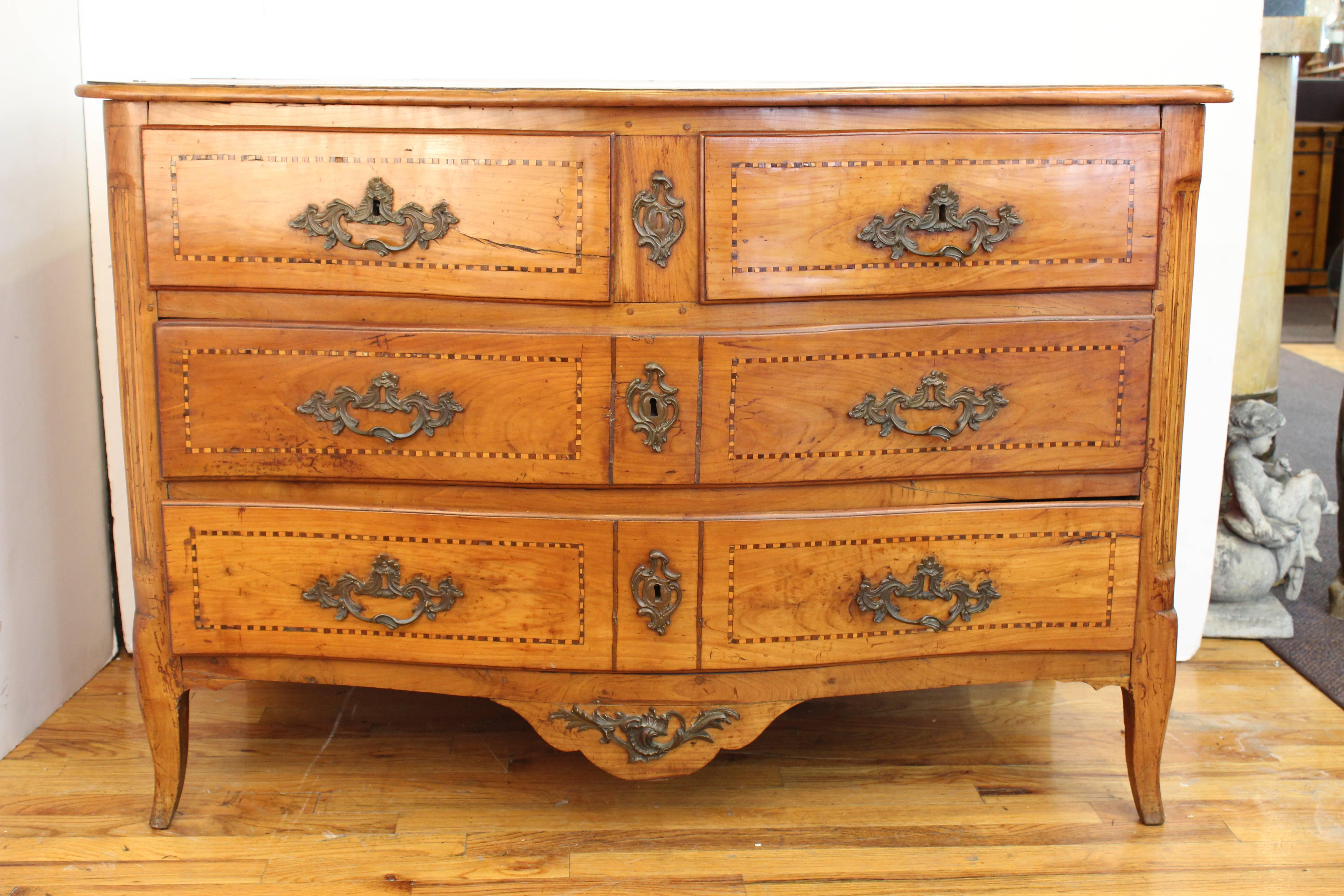 A late 18th century German commode in a Baroque Revival style, in walnut wood with delicate marquetry designs. Two short drawers above two long drawers, raised on swung legs and with Baroque style hardware. Wear appropriate to age and use, in good