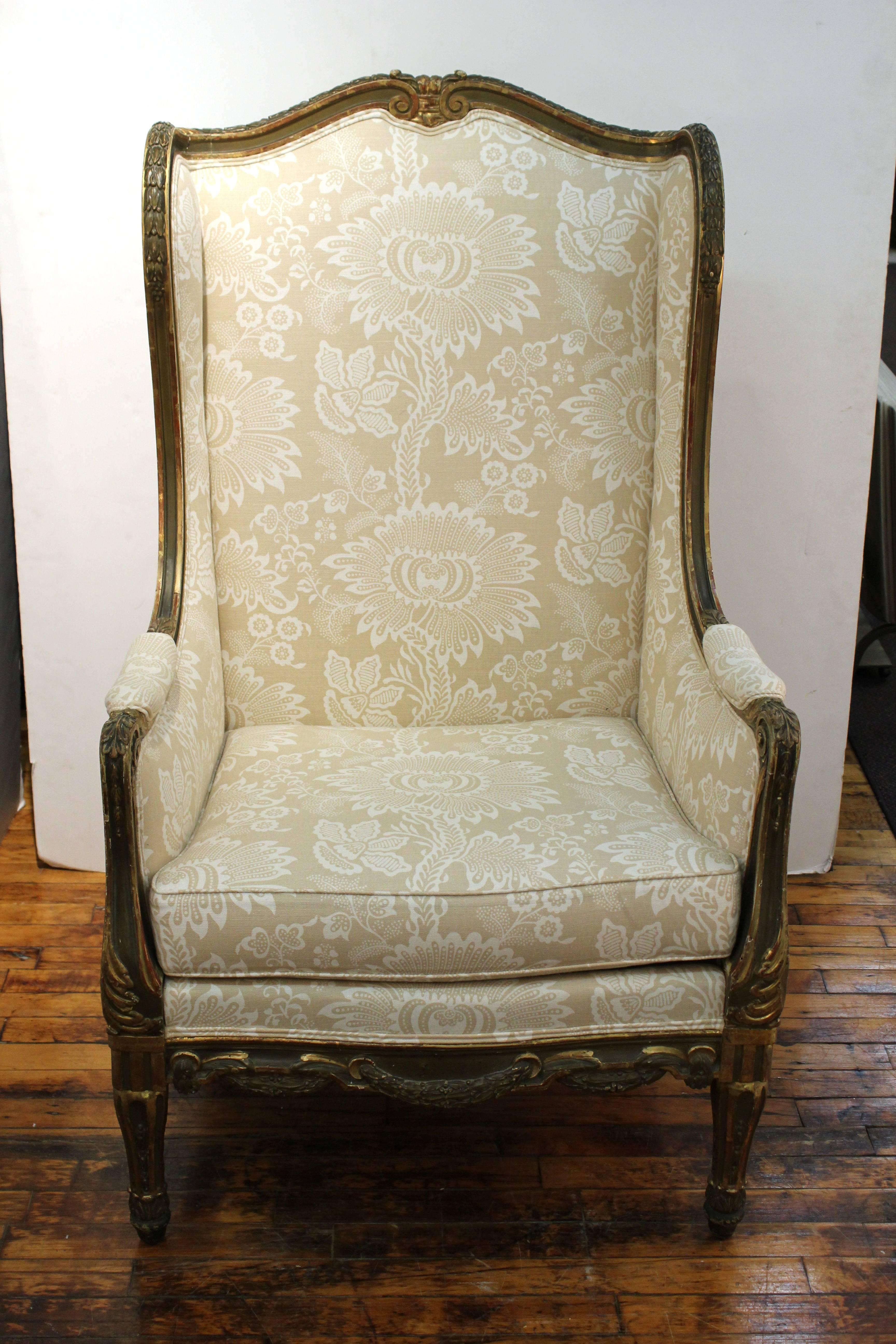 A 19th century French bergère wingback armchair in Louis XVI style. The giltwood frame has delicately carved motifs and tapered fluted legs. Wear appropriate to age and use, in good condition.
