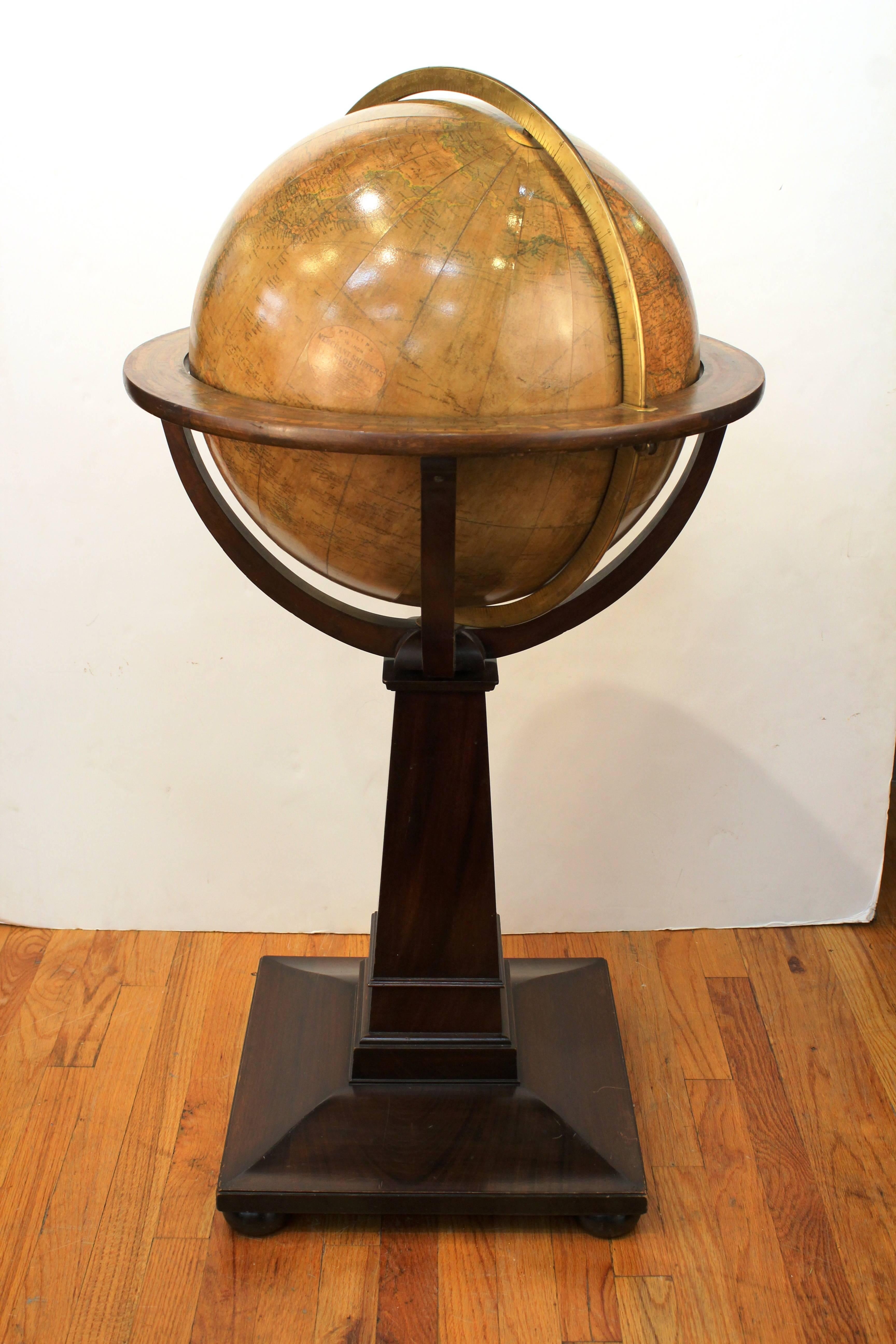 A Philip's 18inch Merchant Shippers Globe from Nov. 1899. Produced in London by George Philip and Son LTD. Includes a brass meridian ring and a horizontal ring with zodiac symbols and calendrical notes. The globe is completely rotational on a wooden