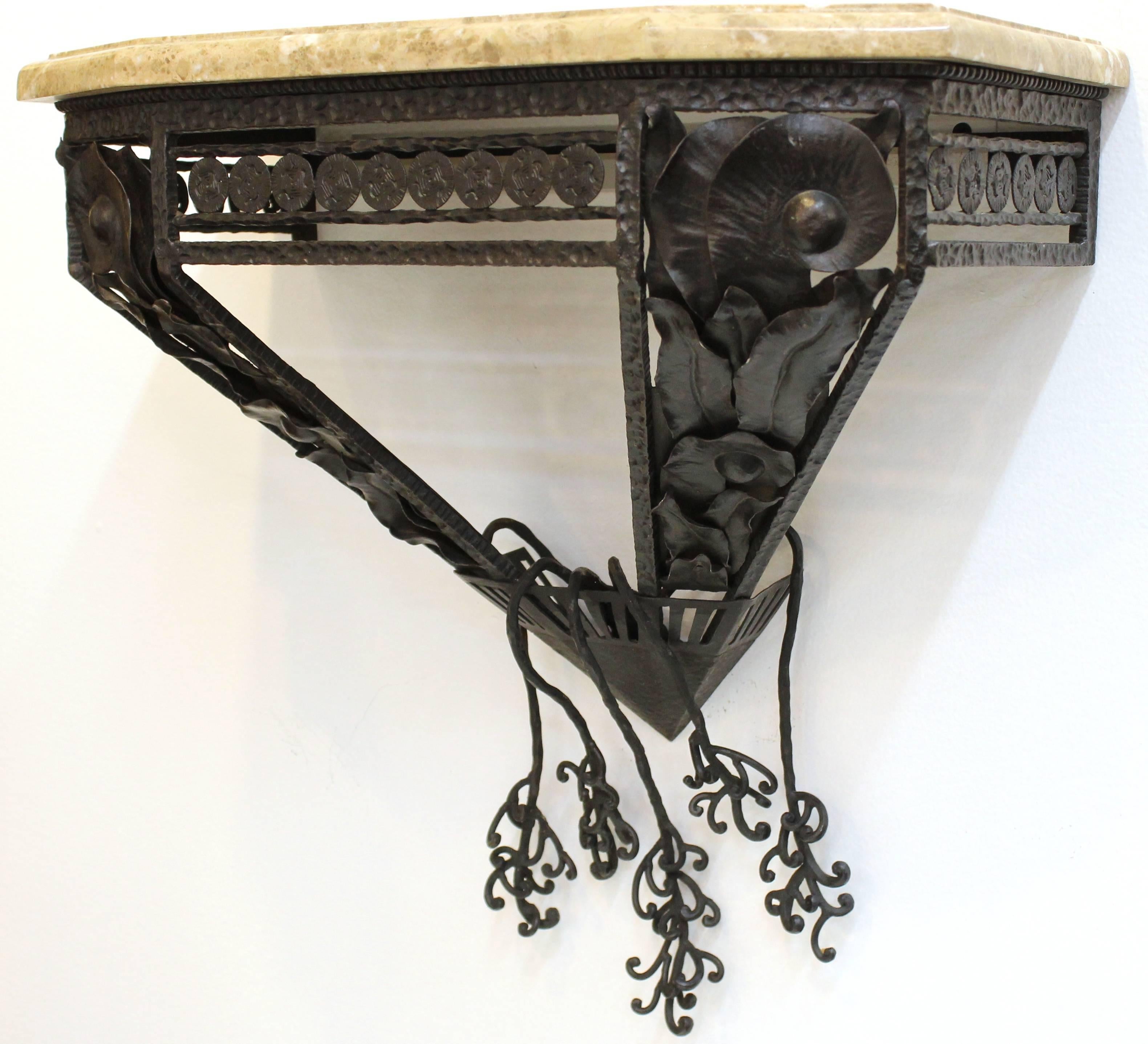 Art-Deco inspired console in the style of Oscar Bach in wrought iron and marble top. The edges of the marble are beveled and the wrought iron features abstracted organic forms. The wall-mounted console is in excellent condition. 110533.
