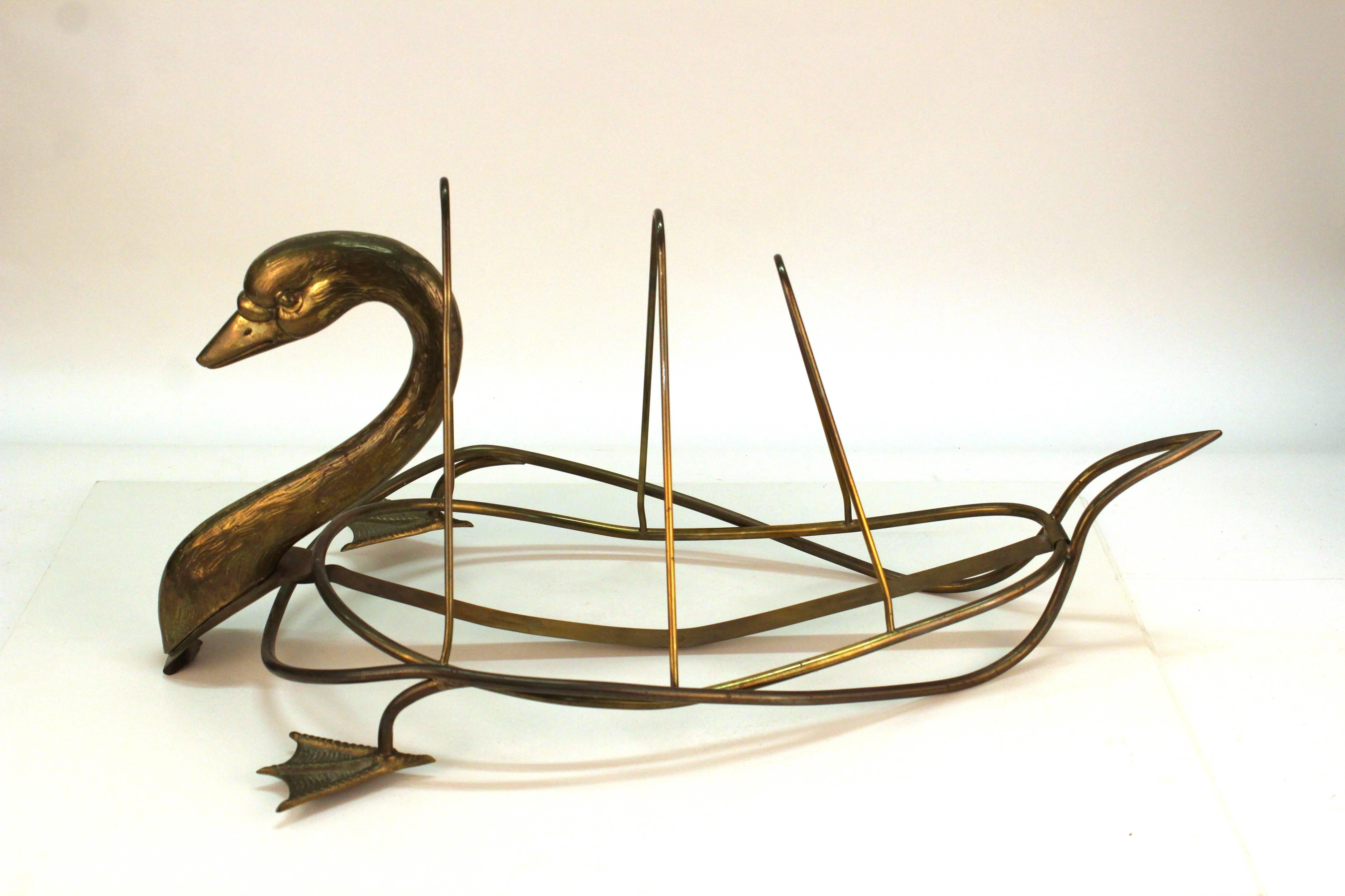 A brass newspaper holder in the shape of a swan by Maison Jansen. Includes life-like head and feet. Three divisions suggest the body of the swan. Despite some wear appropriate to age and use the stand is in good condition.