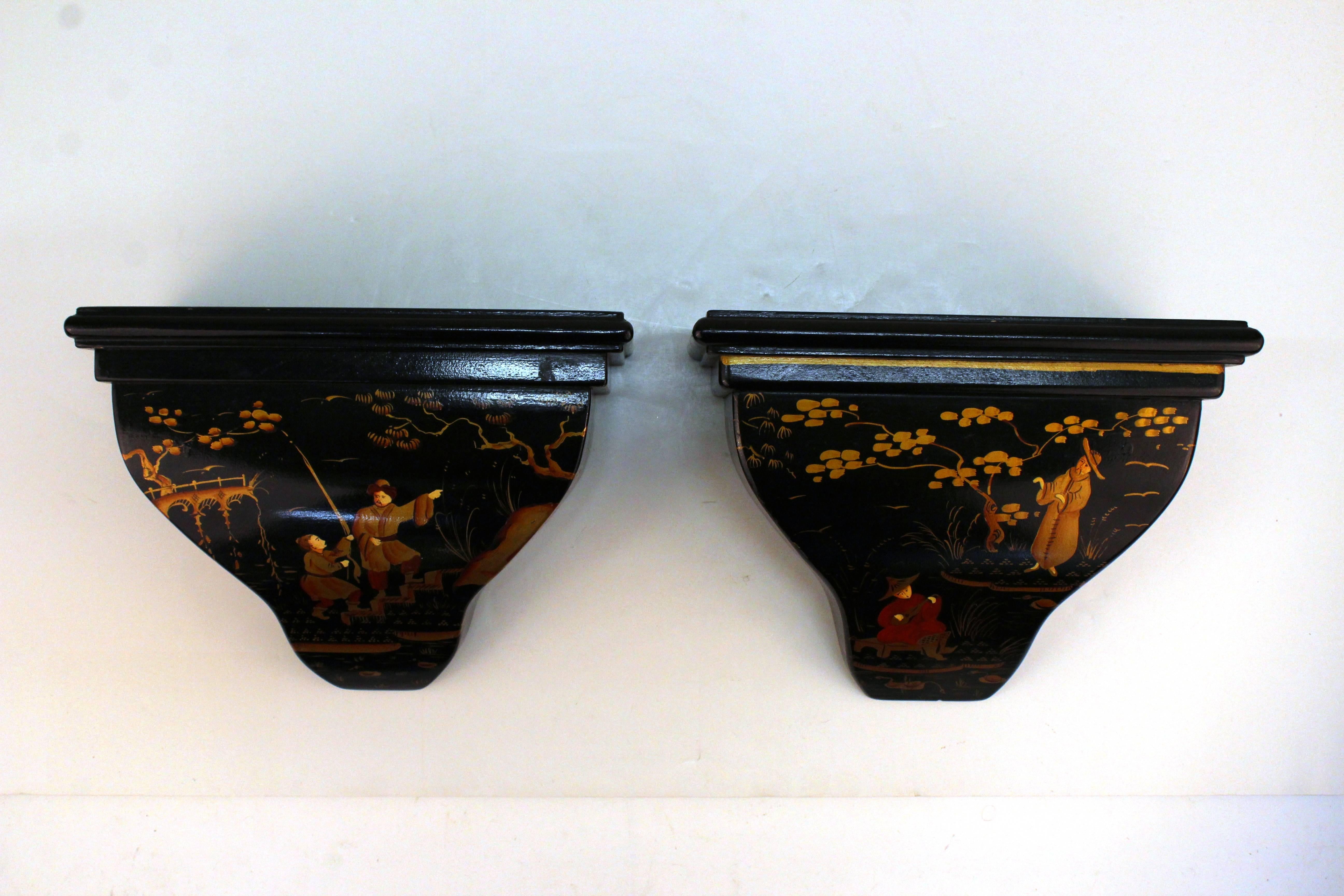 Pair of small wooden shelves by Don Andres. The shelves are black with hand-painted chinoiserie motifs in hues of rust and orange. Includes the original label on the back. Some wear to paint due to use; in good condition.