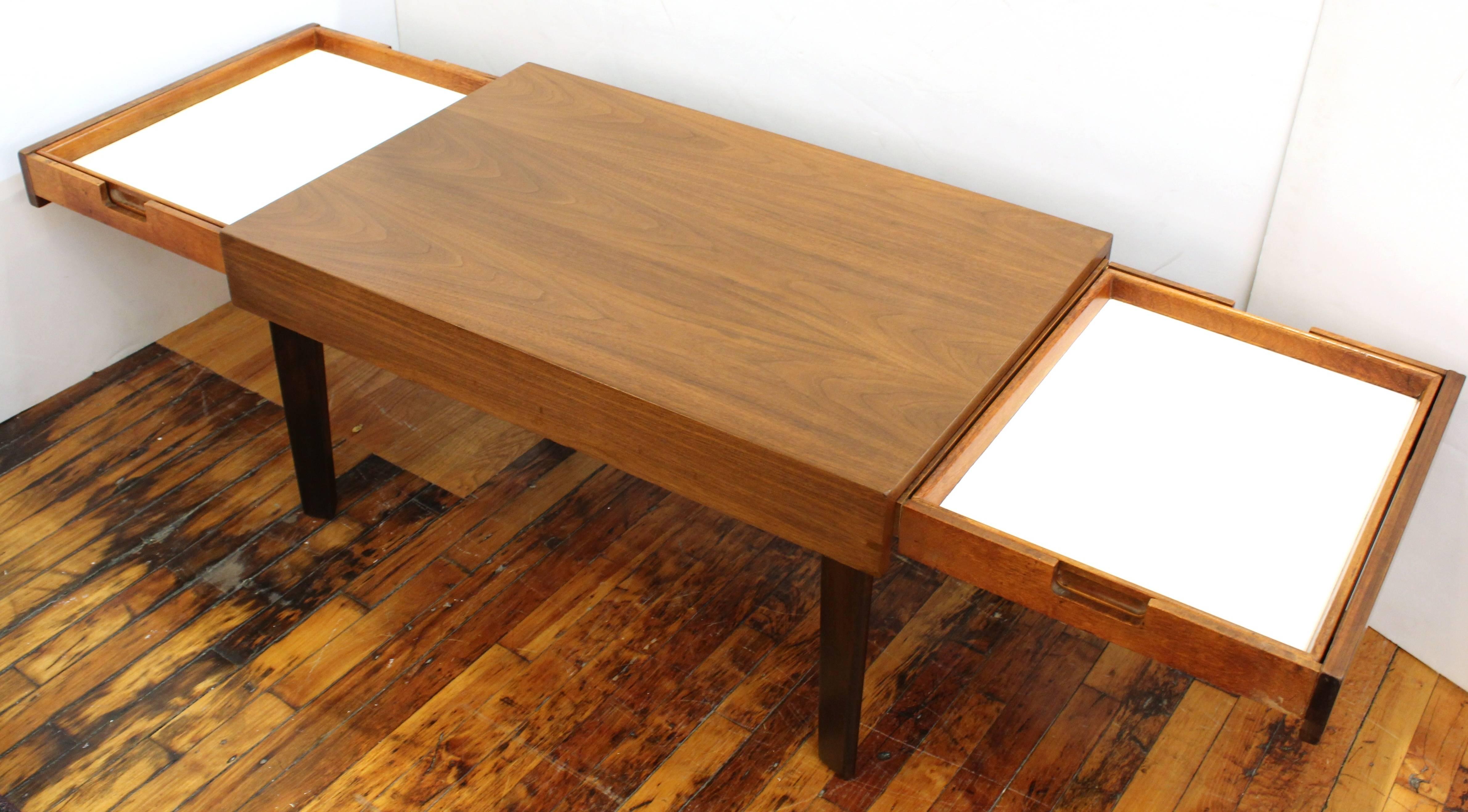 Coffee table by George Nelson for Herman Miller features two extendable drawers. Each drawer is a removable tray that can be inverted to make a writing surface with wood finish. The table is in good vintage condition consistent with age and use.