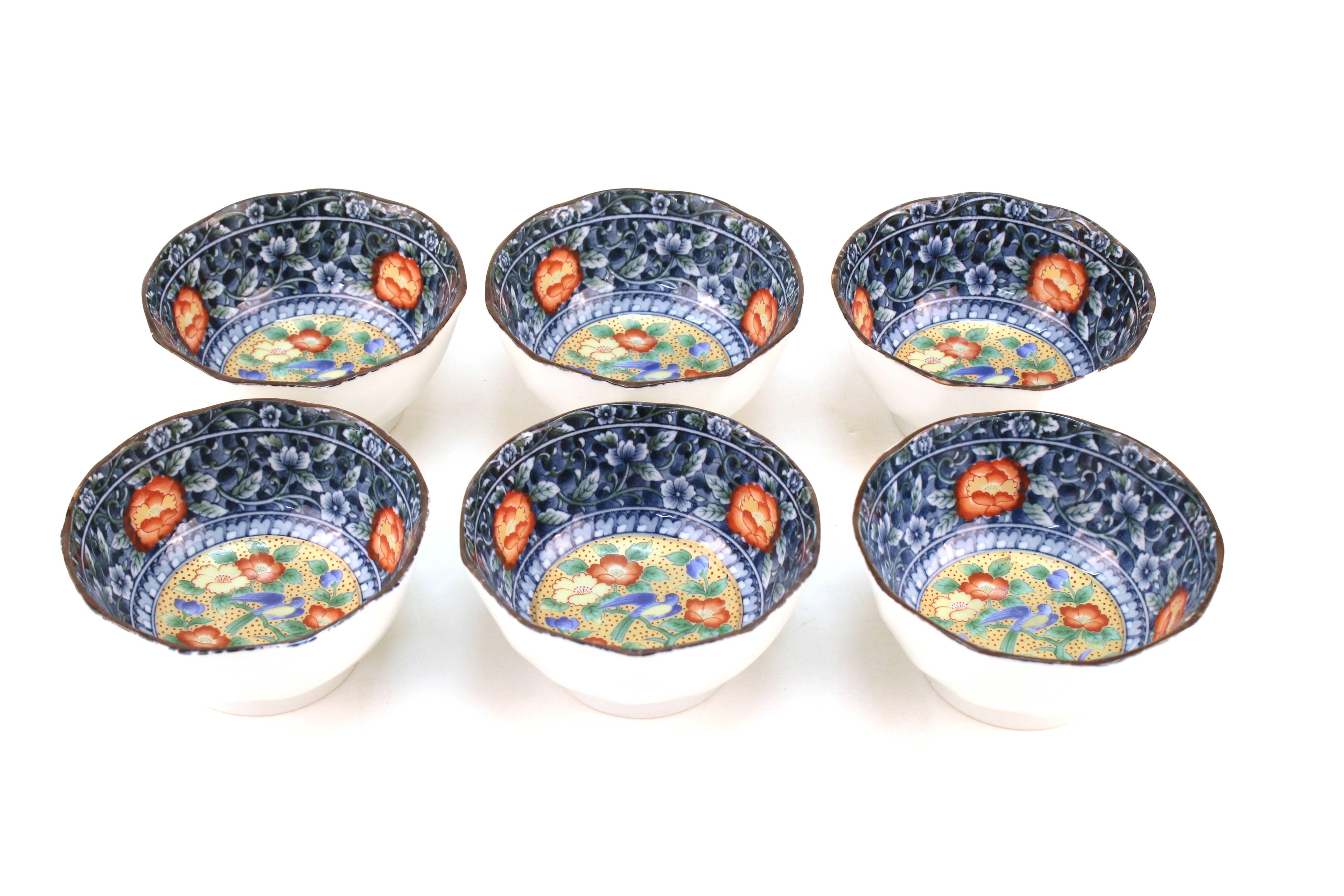 Set of Japanese bowls crafted in ceramic. All six pieces are painted in blue with flowers. Birds decorate the bowl's interior. Stamped on the bottom. Minor wear but in overall good condition.