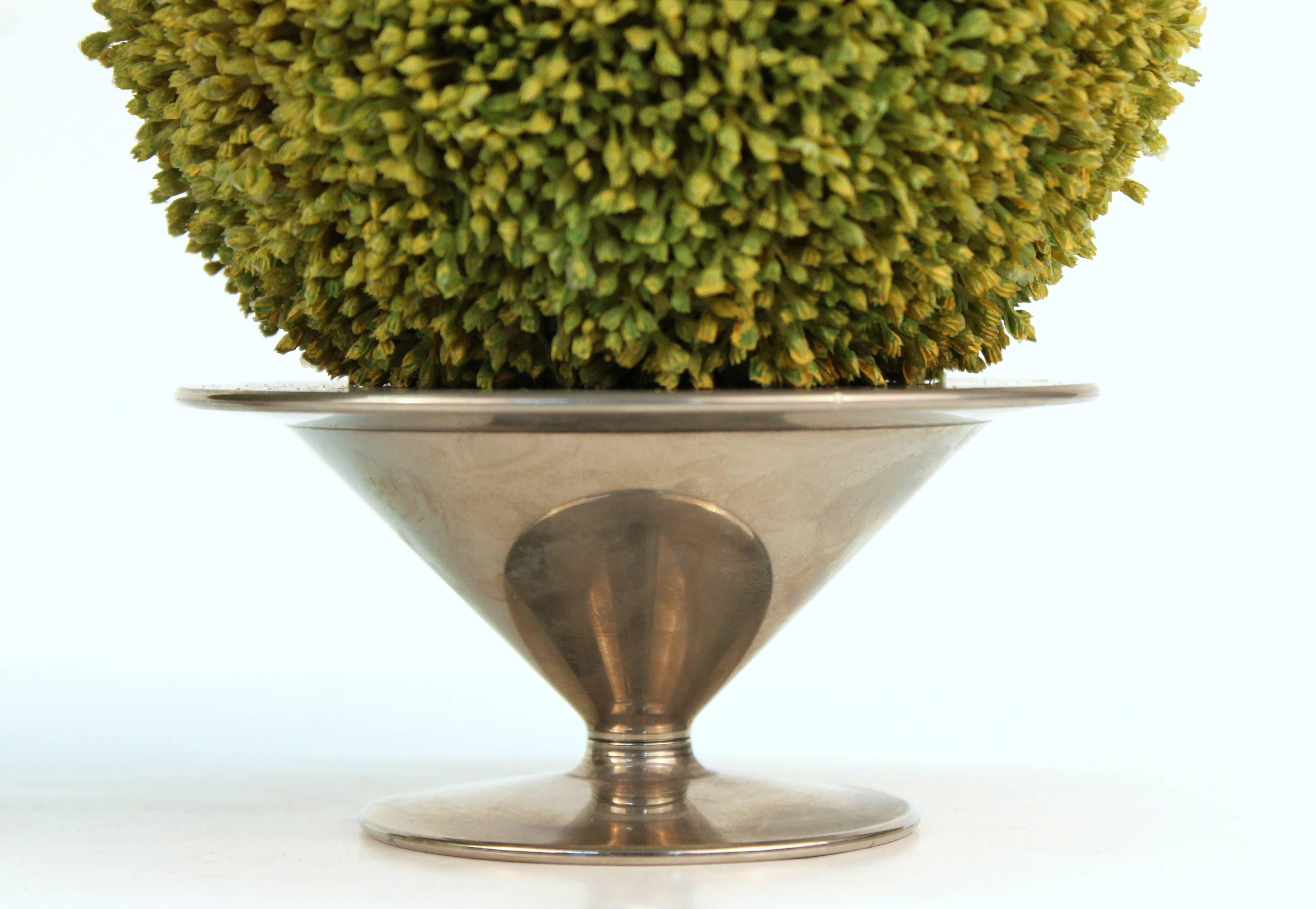 Each of these decorative votive holders feature a small faux topiary shrub in spherical form. The candleholders are in a silver-toned metal, neoclassical Revival form, and are stamped 'Saint Hilare' underneath. The shrubs are not attached to the