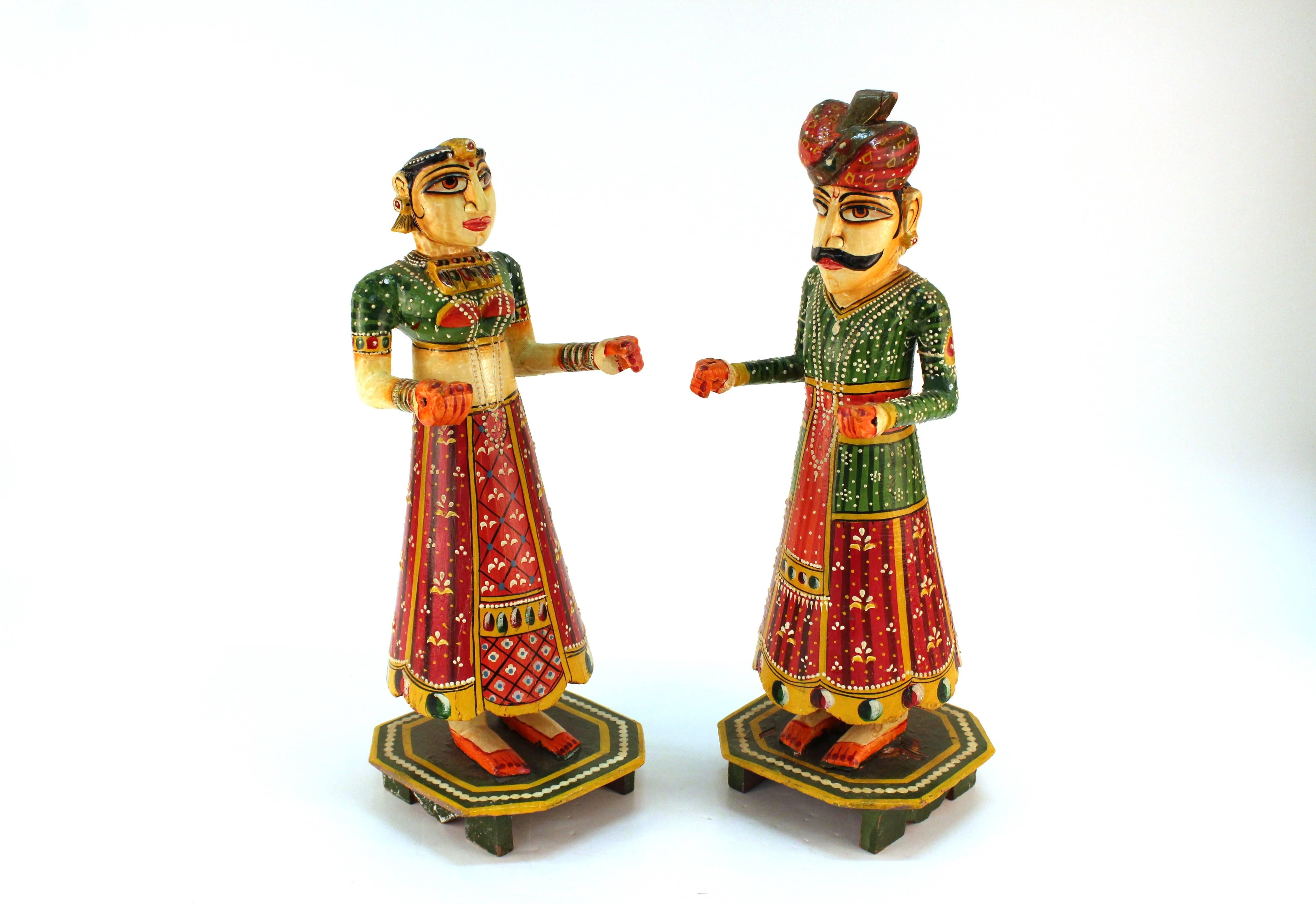 A pair of hand-painted Rajasthan dolls. Crafted for the celebration of Gangaur. The dolls depict Gauri and Issar in wedding attire. Each figure stands on an octagonal base. The figures are in good condition.