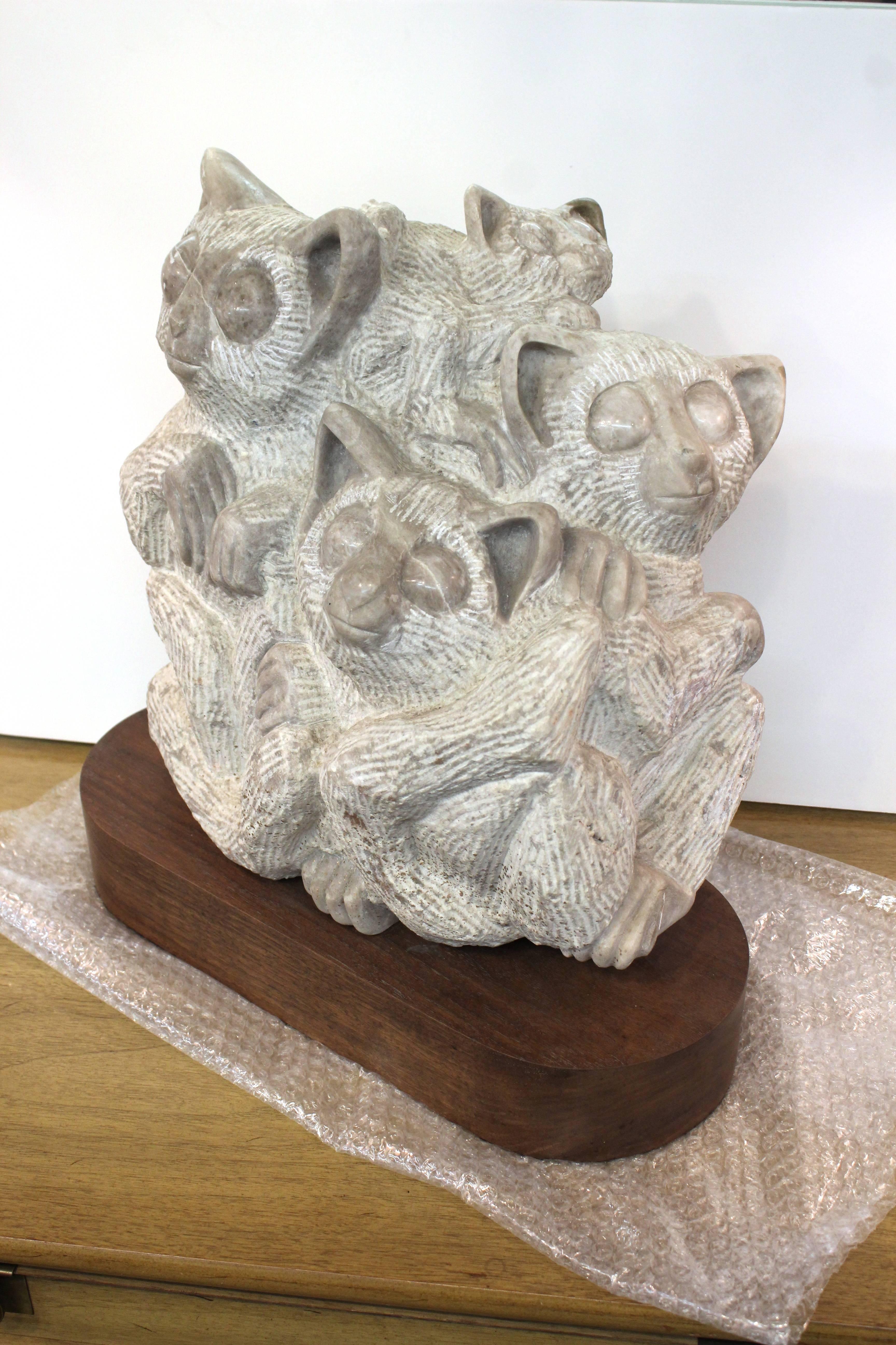 Midcentury lemur sculpture. Carved in marble and mounted on a wood base. The sculpture depicts several lemurs huddled together. The piece remains in very good condition.
