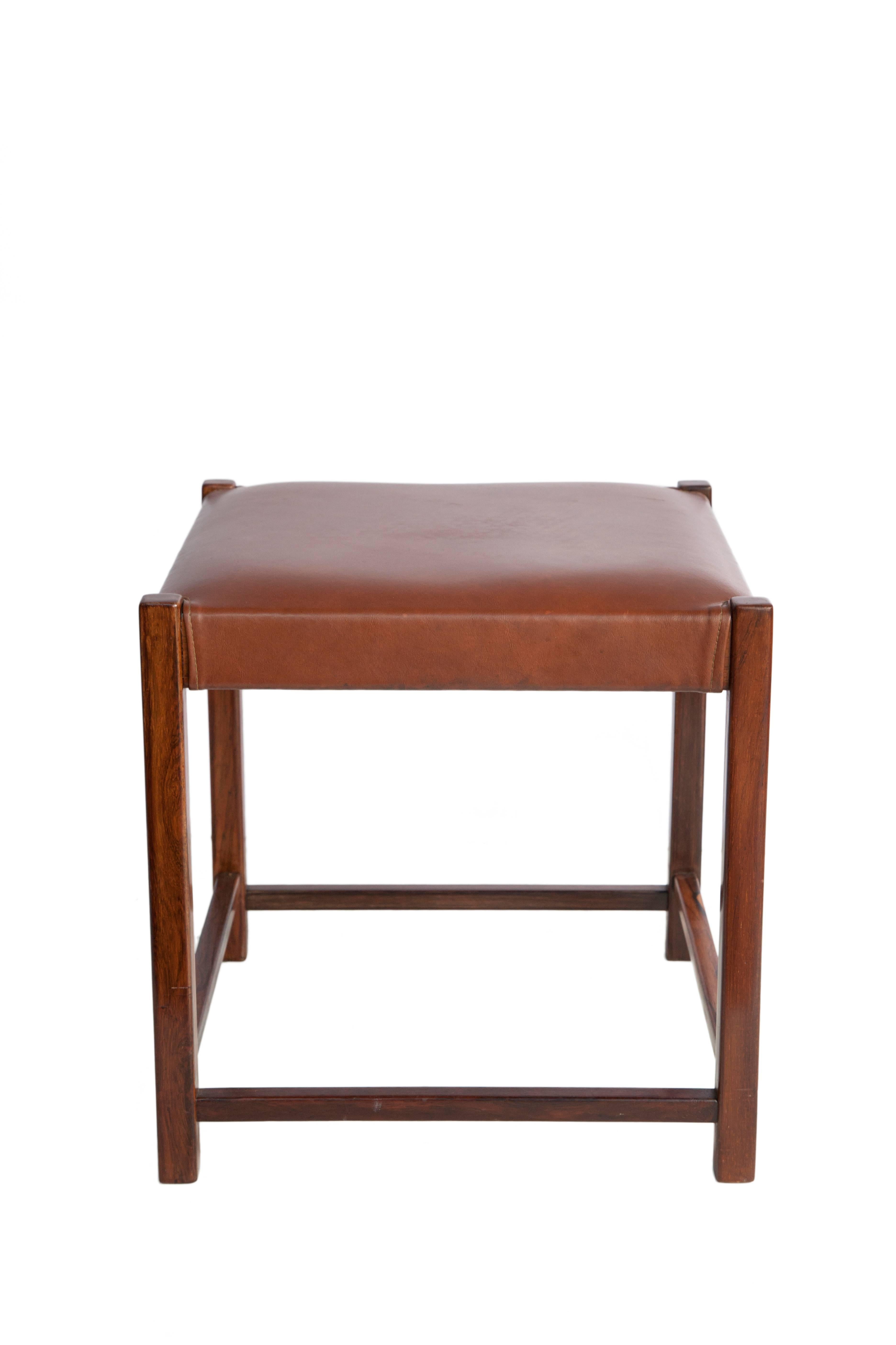 A Mid-Century Modern stool in Brazilian Jacaranda wood, with its original leather seat. Made in the 1960s in Brazil by Mobilinea. The piece is in great vintage condition, with wear appropriate to use and age. Original Mobilinea seal underneath the