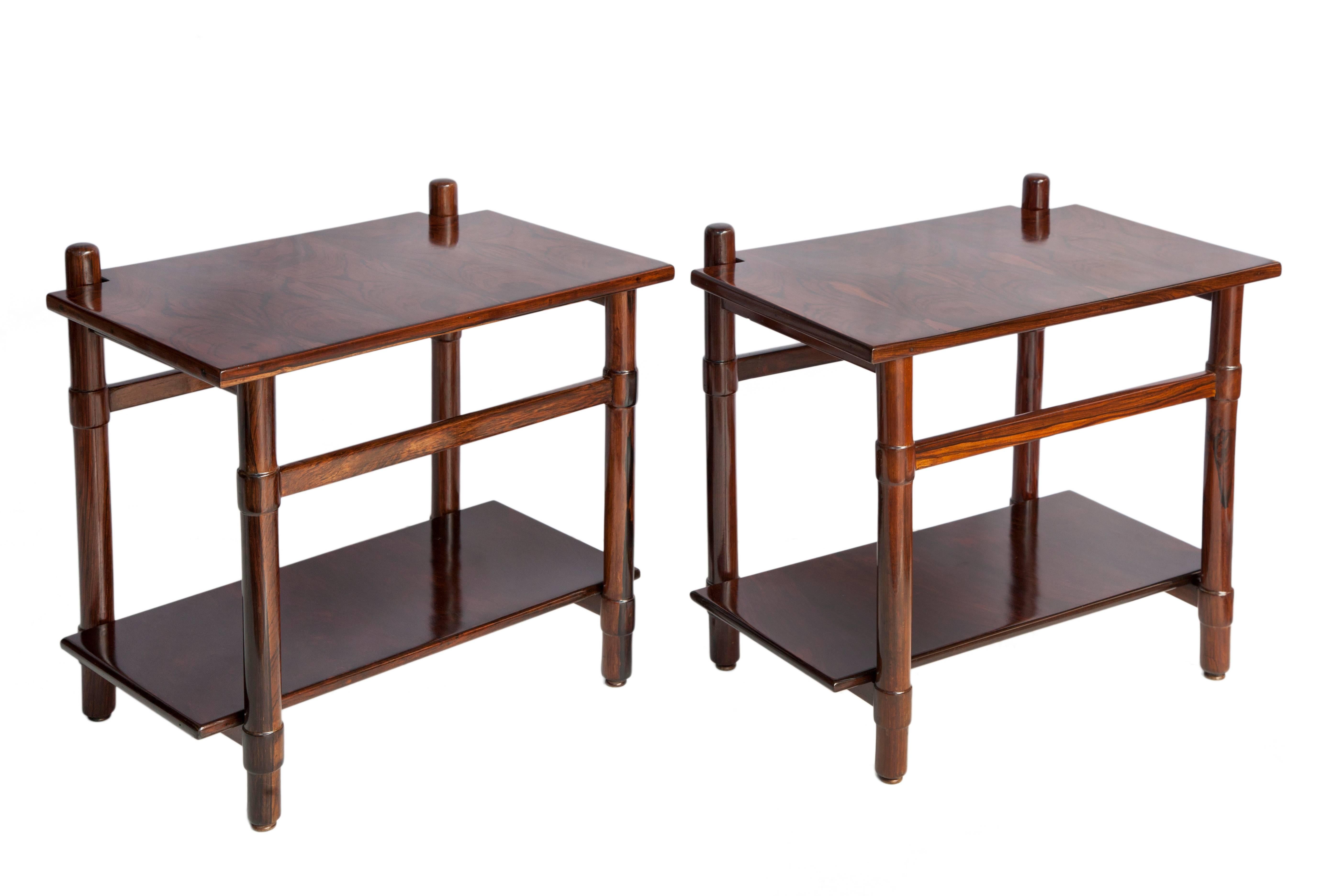 Brazilian Mid-Century Modern Michel Arnoult side tables. Completely crafted in Brazilian Jacaranda wood. Consists of two levels with a solid bottom shelf. Stands on four square legs with trestle accents. The pair are in good vintage condition with