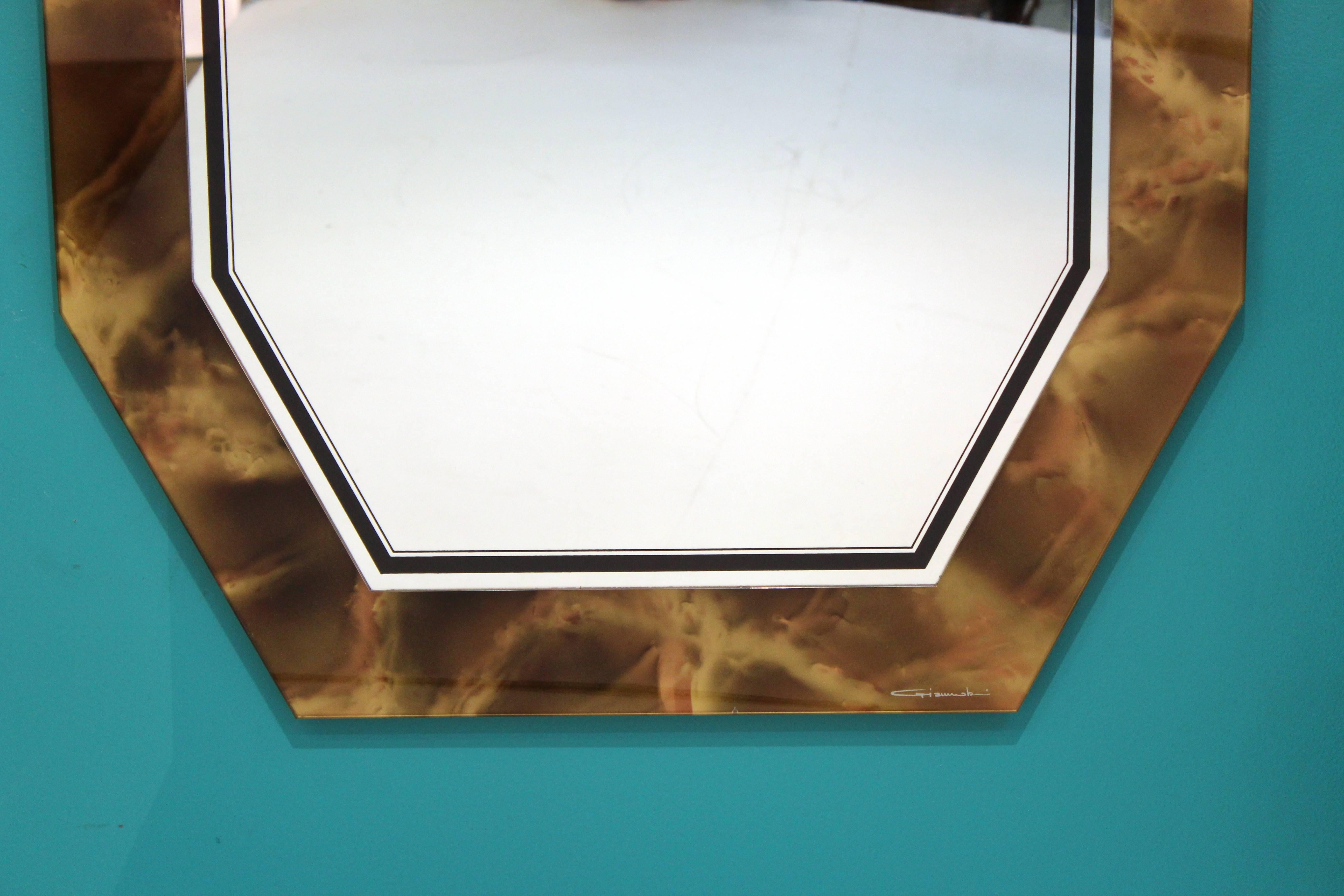 Italian Mid-Century Modern style reverse painted faux tortoise shell mirror in elongated octagonal shape. The piece was made in Italy in the 1970s and is in very good vintage condition. Non-descriptive signature on the bottom border.