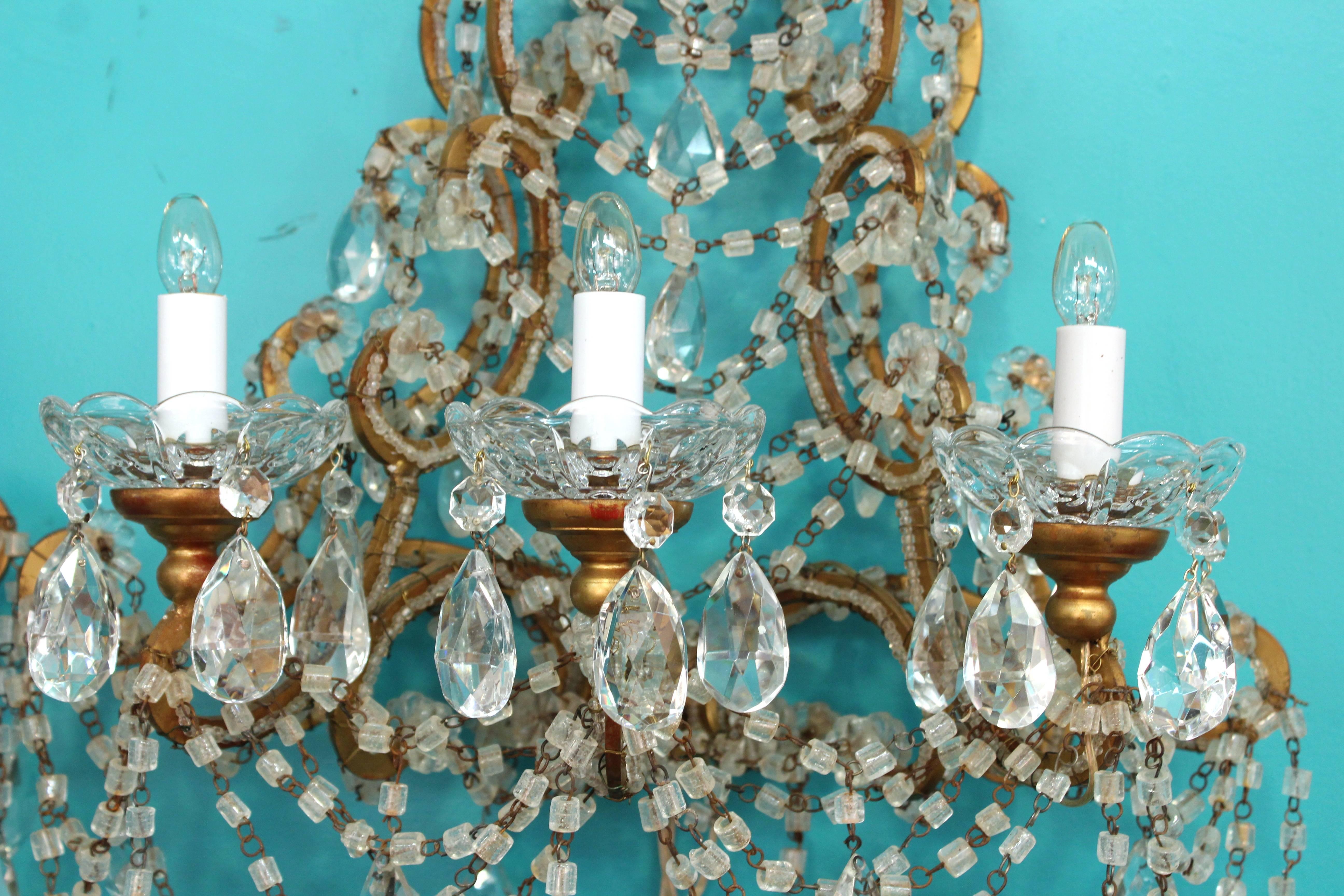 A pair of large Italian Marie Antoinette brass sconces with crystals and beads. Made in Italy in the 1950s. The pair has recently been re-wired to fit US standards. Each sconce takes three candelabra base bulbs. In very good vintage condition.