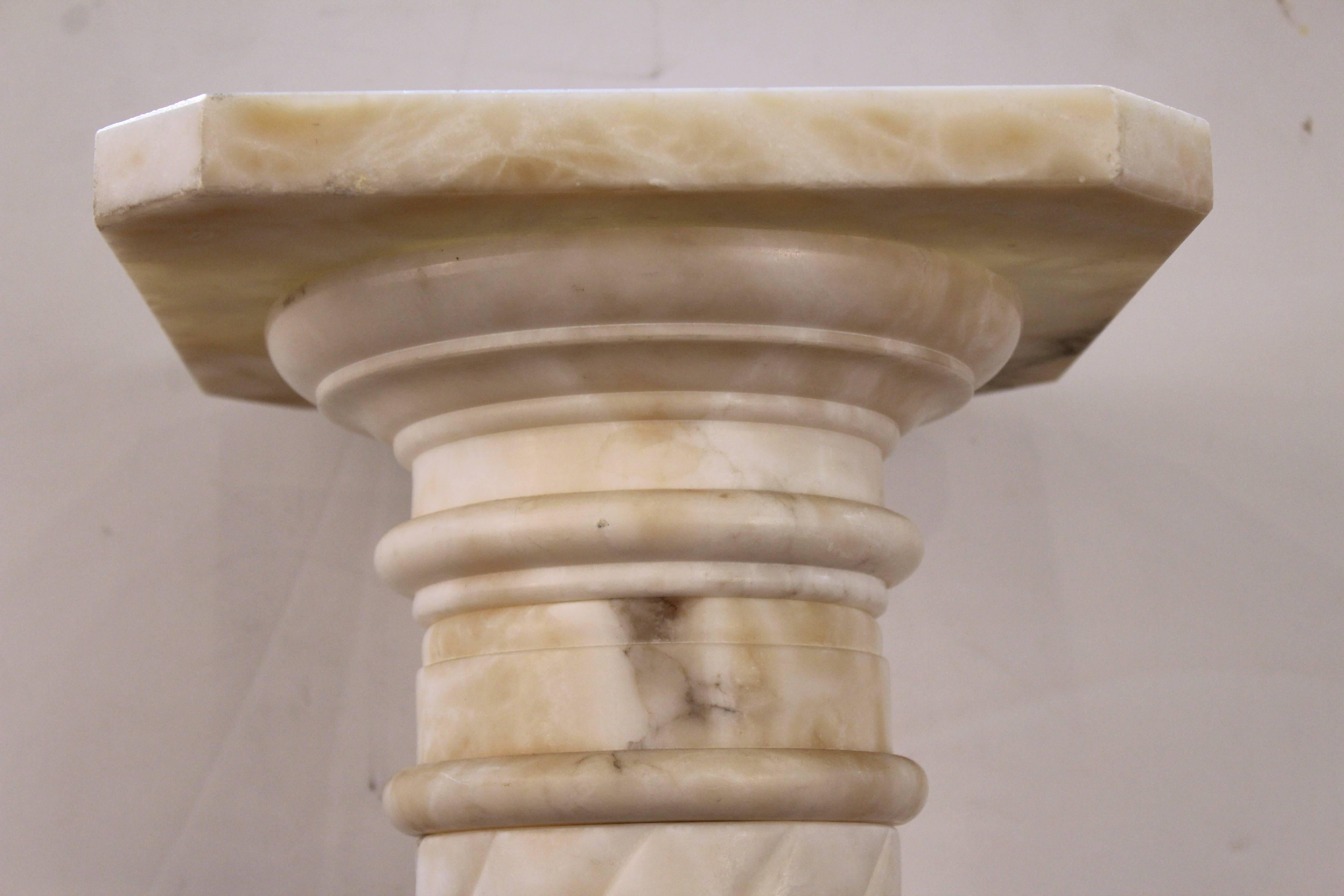 A Victorian pedestal in sculpted white marble. The marble shaft is in a twisted form and has a central ring with stylized motive of sculpted leaves. In very good vintage condition with age appropriate use and wear.