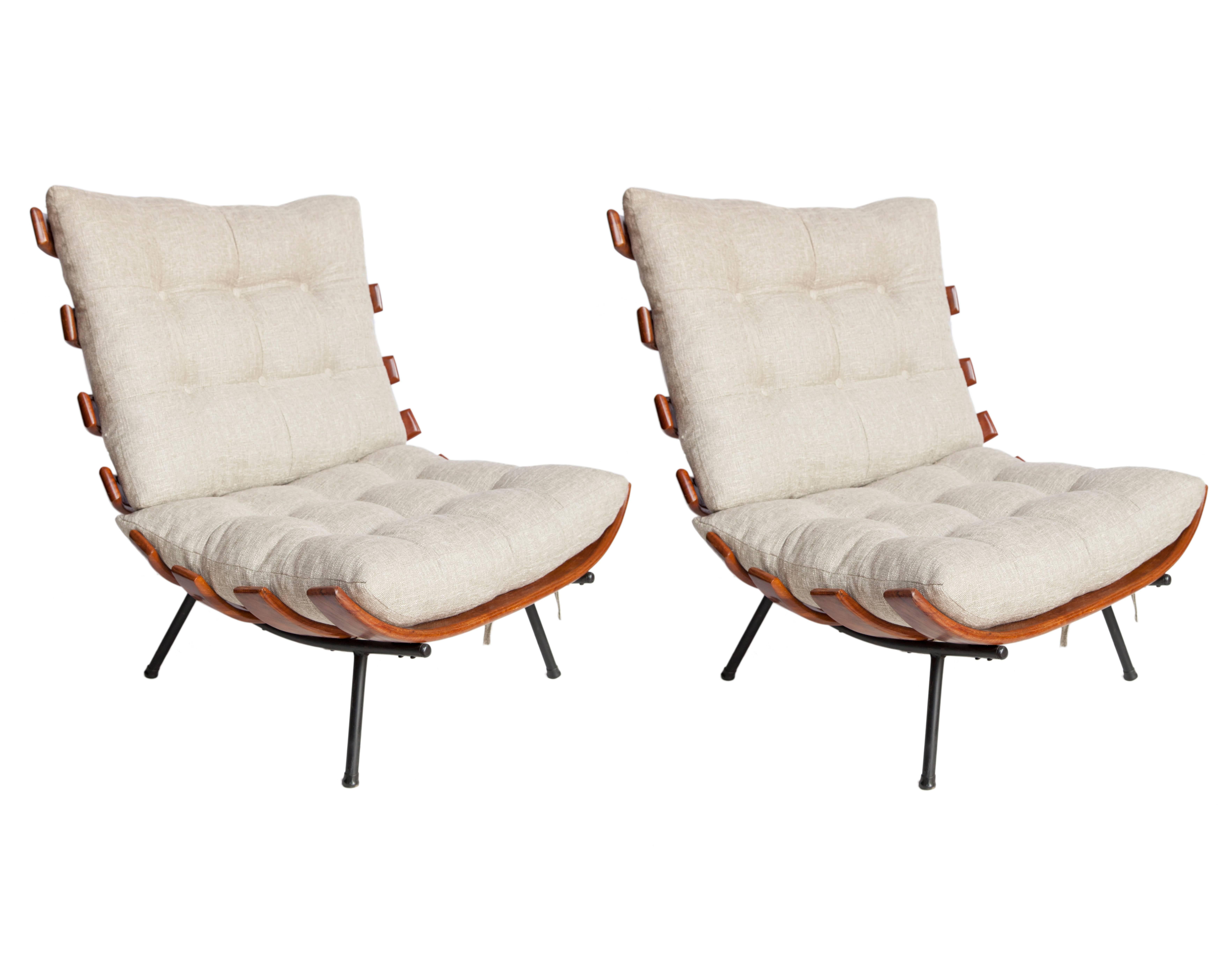 Brazilian Mid-Century Modern lounge chairs attributed to Martin Eisler. Crafted in caviuna wood with metal feet, circa 1950. This iconic design features a frame made up of curved slates with recently re-upholstered cushions in beige linen. The pair