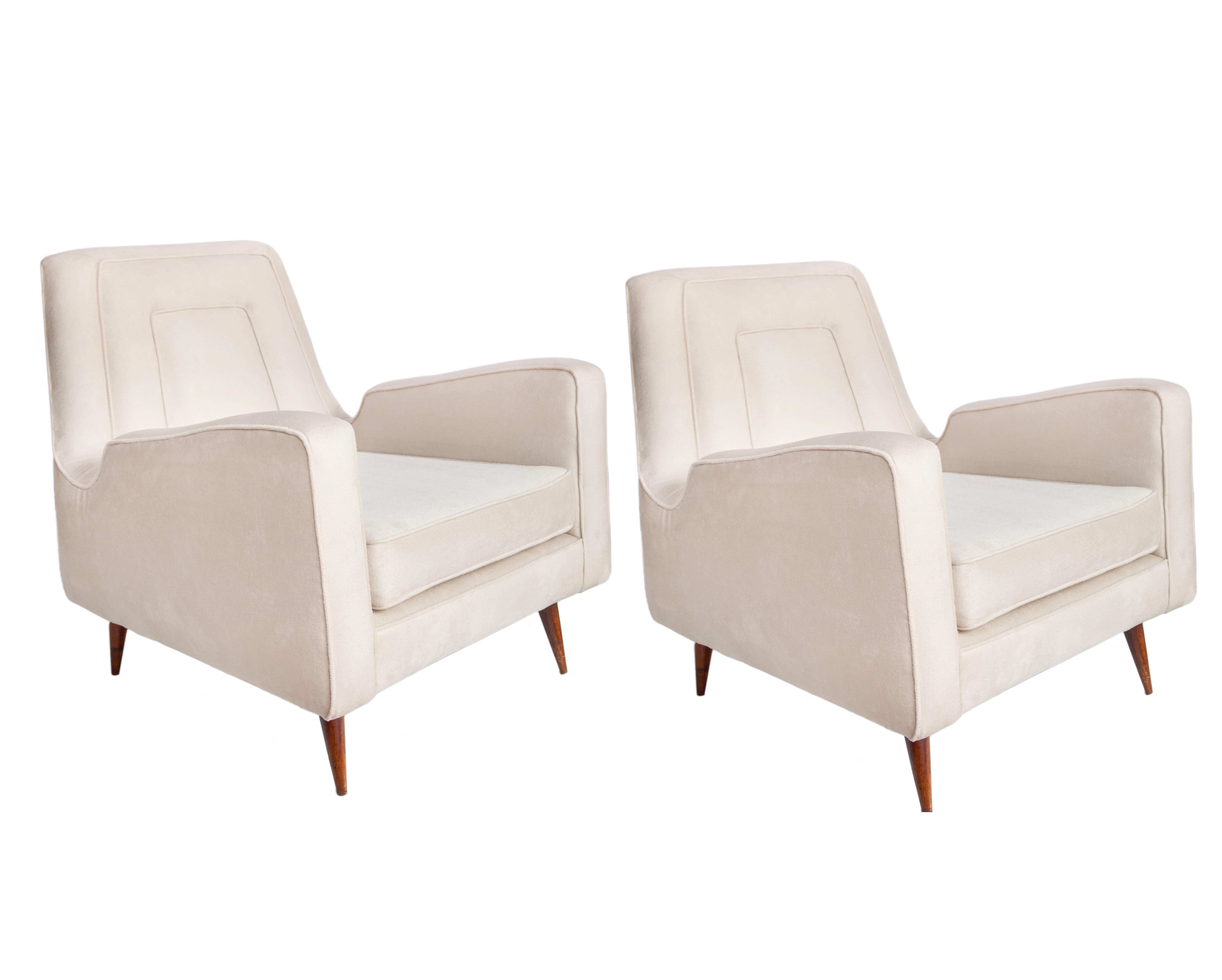 Brazilian Mid-Century Modern armchairs dating from the 1950s in caviuna wood. Each has been recently reupholstered in beige artificial suede. These chairs are in good vintage condition and have wear consistent with age and use.