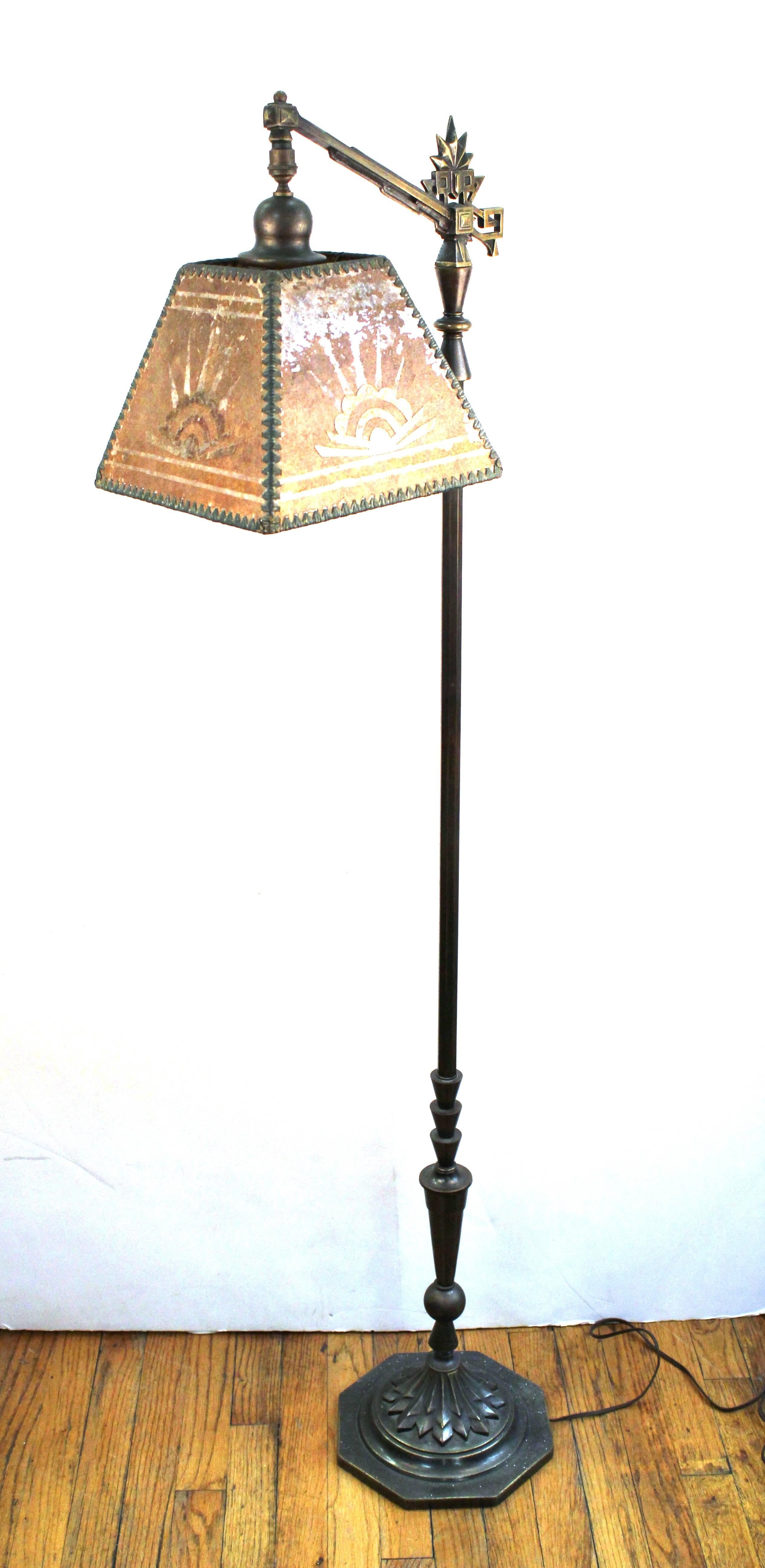 A metal floor lamp from the Art Deco period, with its original Mica lampshade. The piece has an intricate design reminiscent of the Mayan Revival movement of the 1920s and 1930s. In great vintage condition, with age appropriate wear and use.