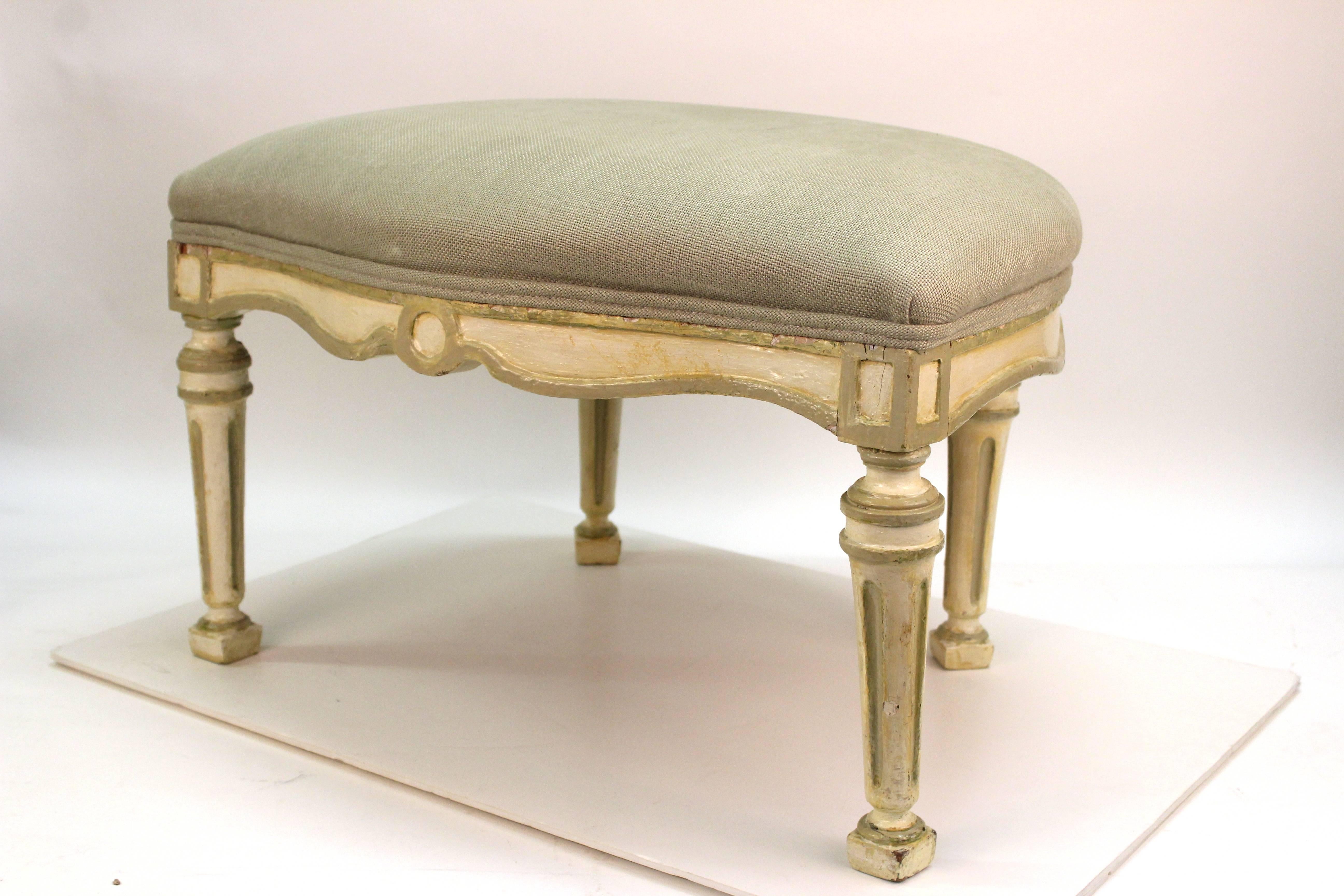 Directoire style wooden bench from France. Painted in cream with darker accents. The seat is upholstered in pale green. Wear appropriate to age and material; with some chips to the wood and paint loss. The piece is in good vintage condition.