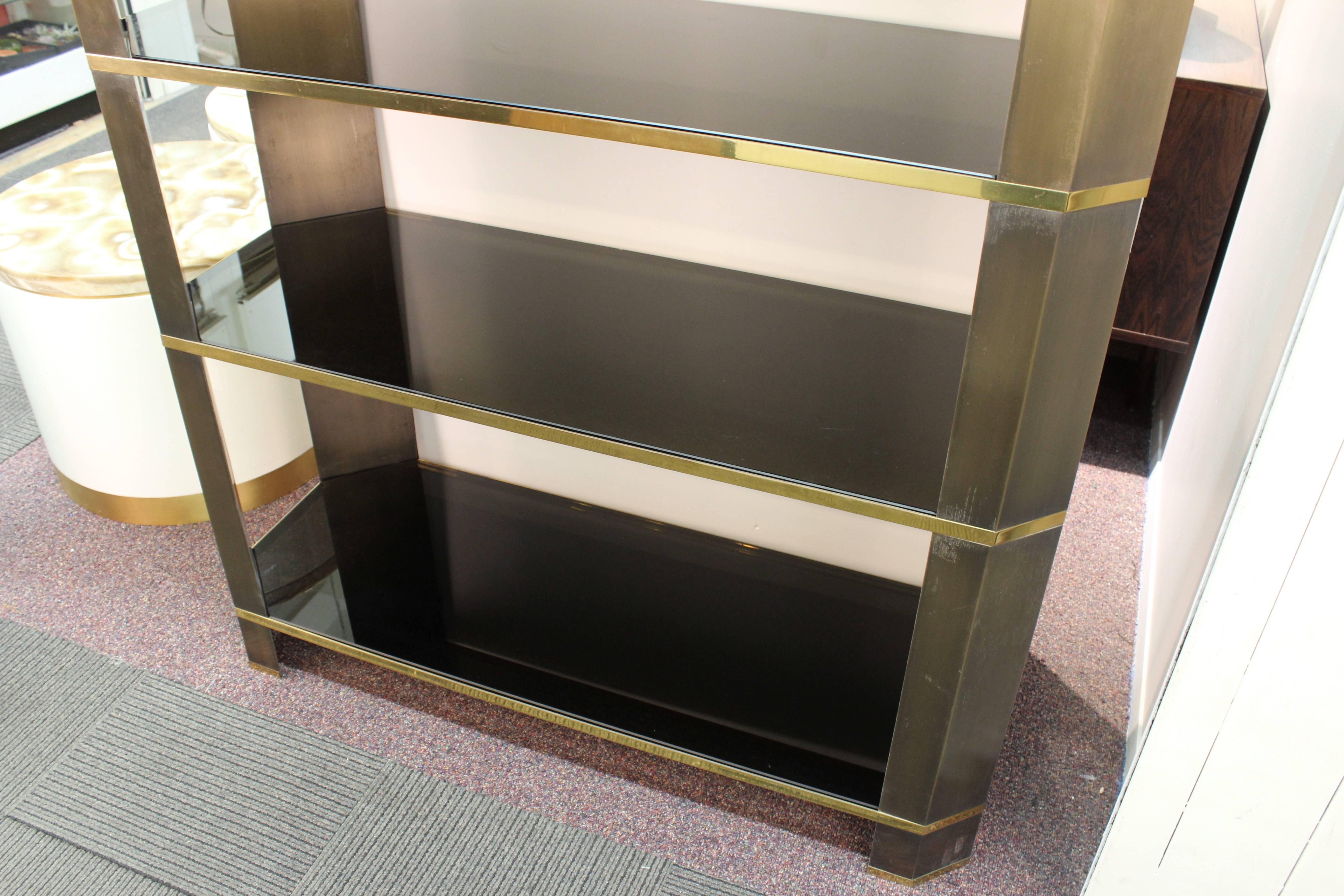 A monumental sized etagere with a bronze structure and shelves made of thick smoked glass, possibly made in the 1970's. The piece has a few scratches but is in overall good vintage condition, with age appropriate use.