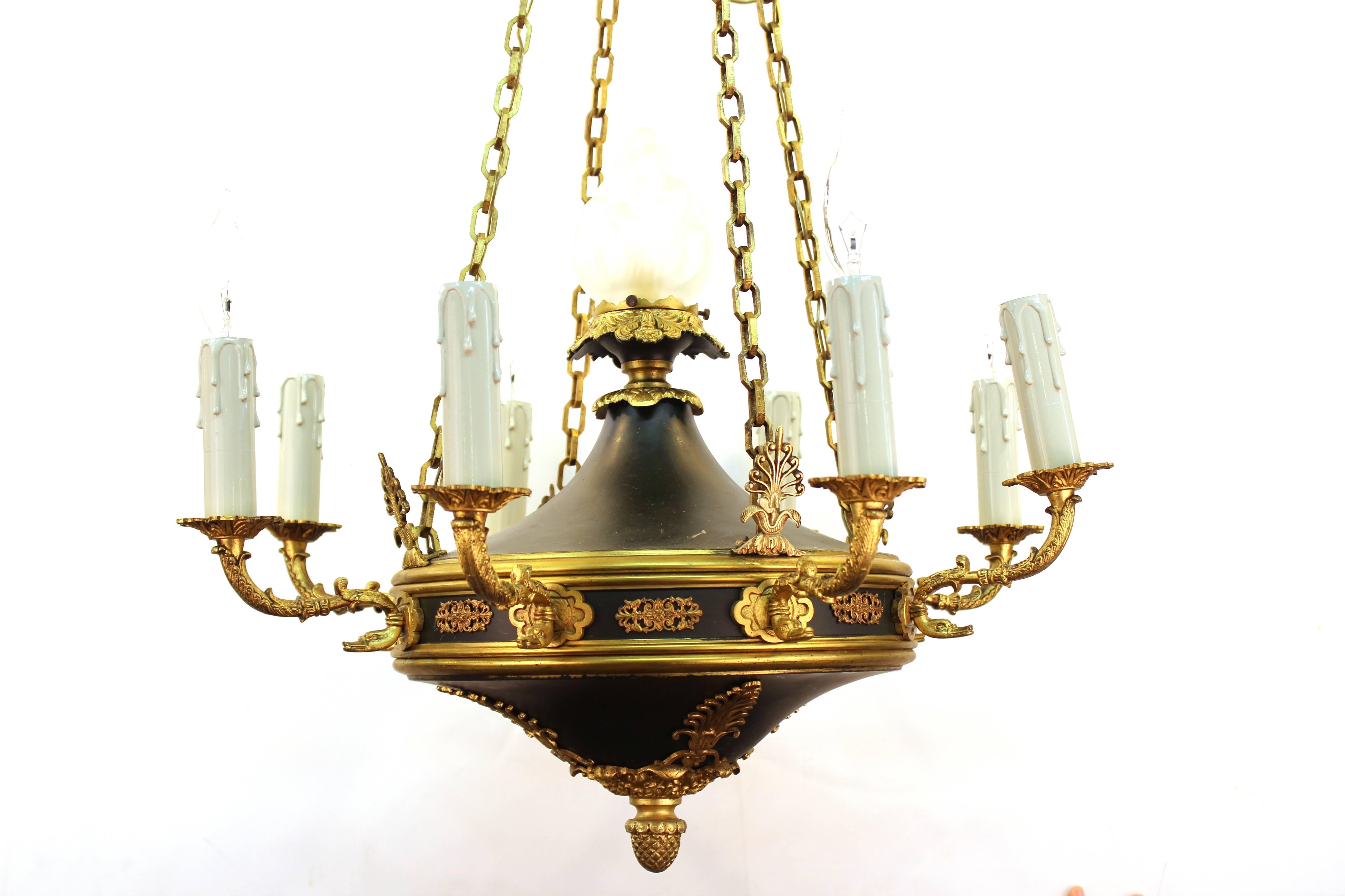 A 19th Century French Empire Chandelier. Includes nine lights with faux candle sockets. Features a rare dark olive green enamel body with gilded decoration.  Recently re-wired to US standards. This fixture remains in very good condition.
