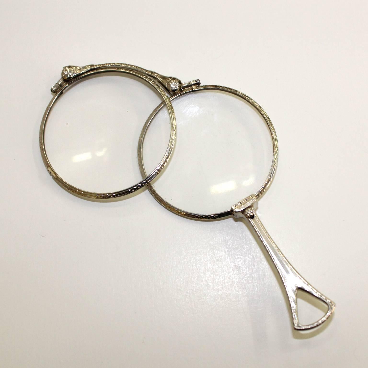 White gold Art Deco folding lorgnette, folds into a single magnifying glass. The bridge marked 10K. In very good condition, wear appropriate to age and use.
