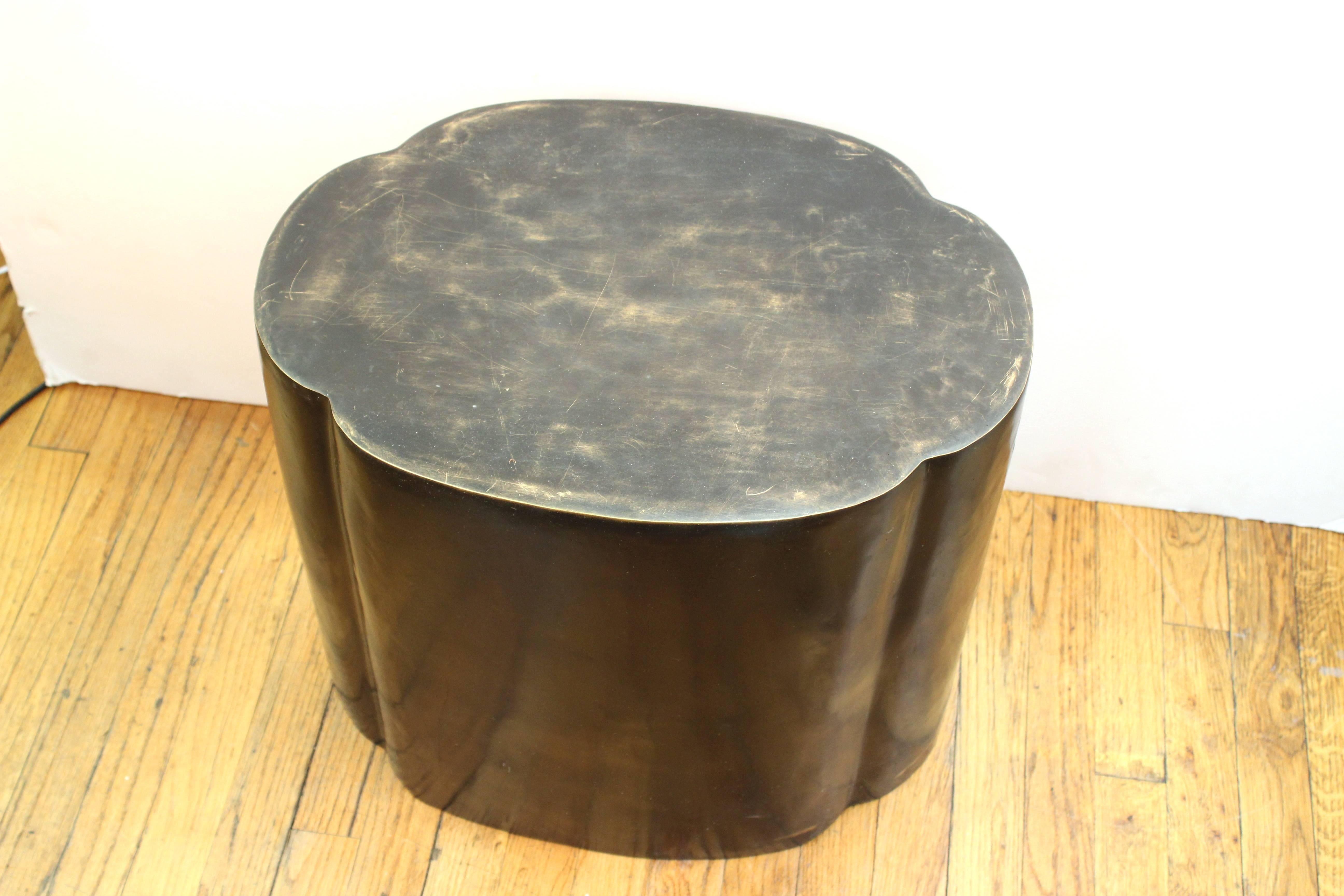 Garden stool in bronze. Lozenge shaped and hollow with cut-outs on each side. Wear to surface and patina due to use and material. The stool is in good condition.