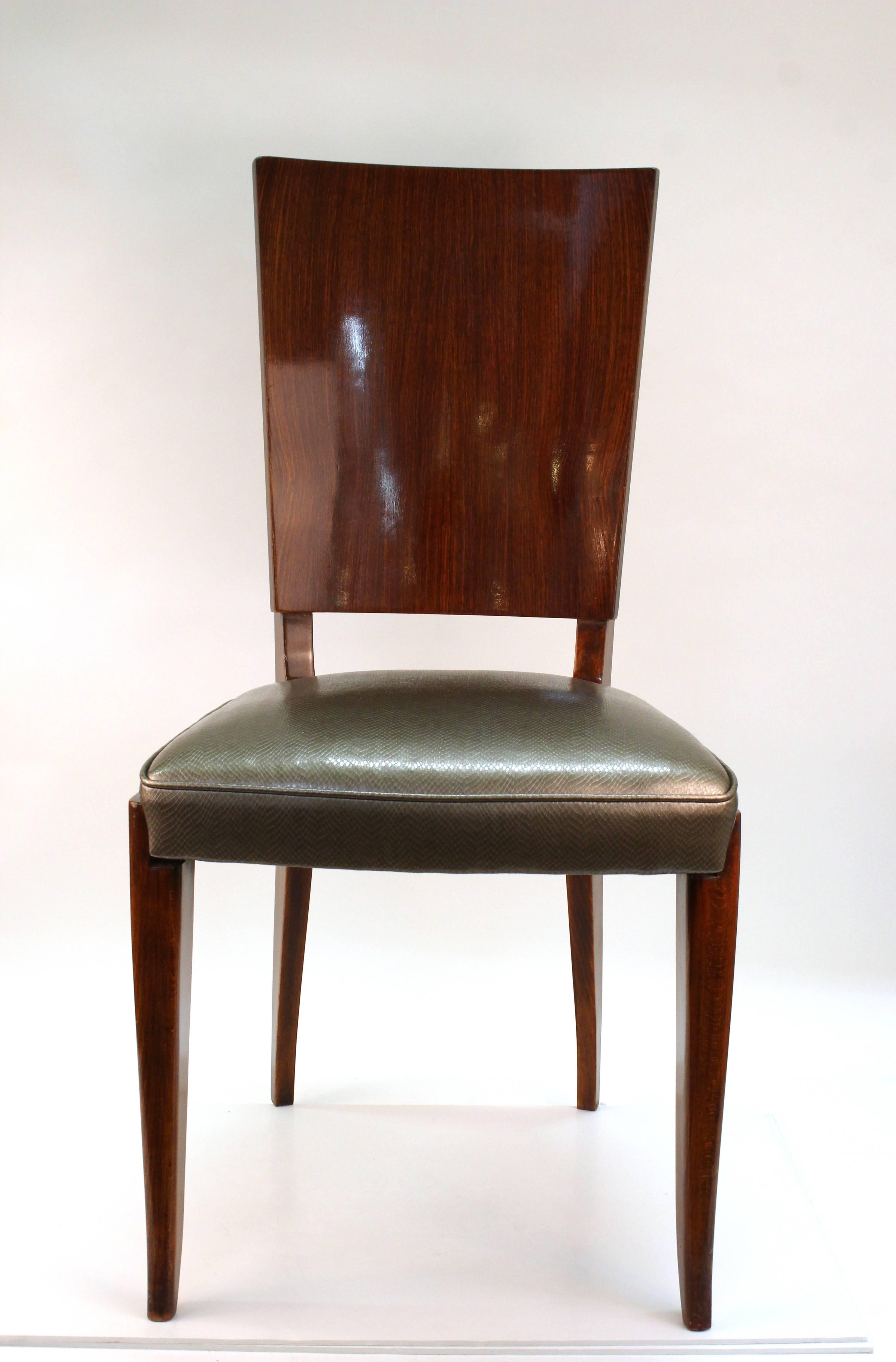 A set of six dining chairs from the Art Deco period, made of rosewood. The set has recently reupholstered seats in silver tone faux vinyl snakeskin. In great vintage condition.