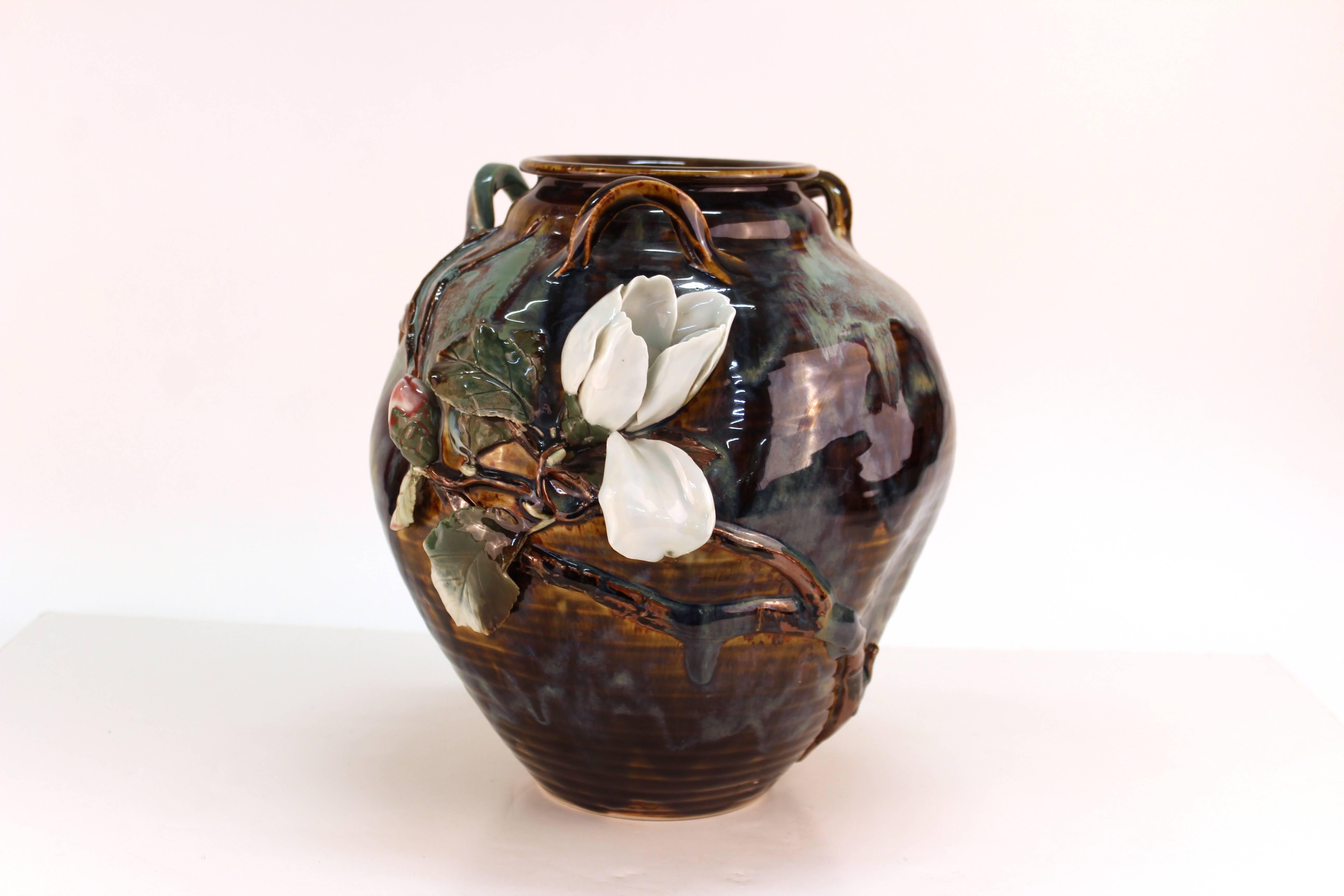 A vase in glazed ceramic with decorative raised flowers. The piece was manufactured in Japan and dates to the period of 1900-1920. In great vintage condition.