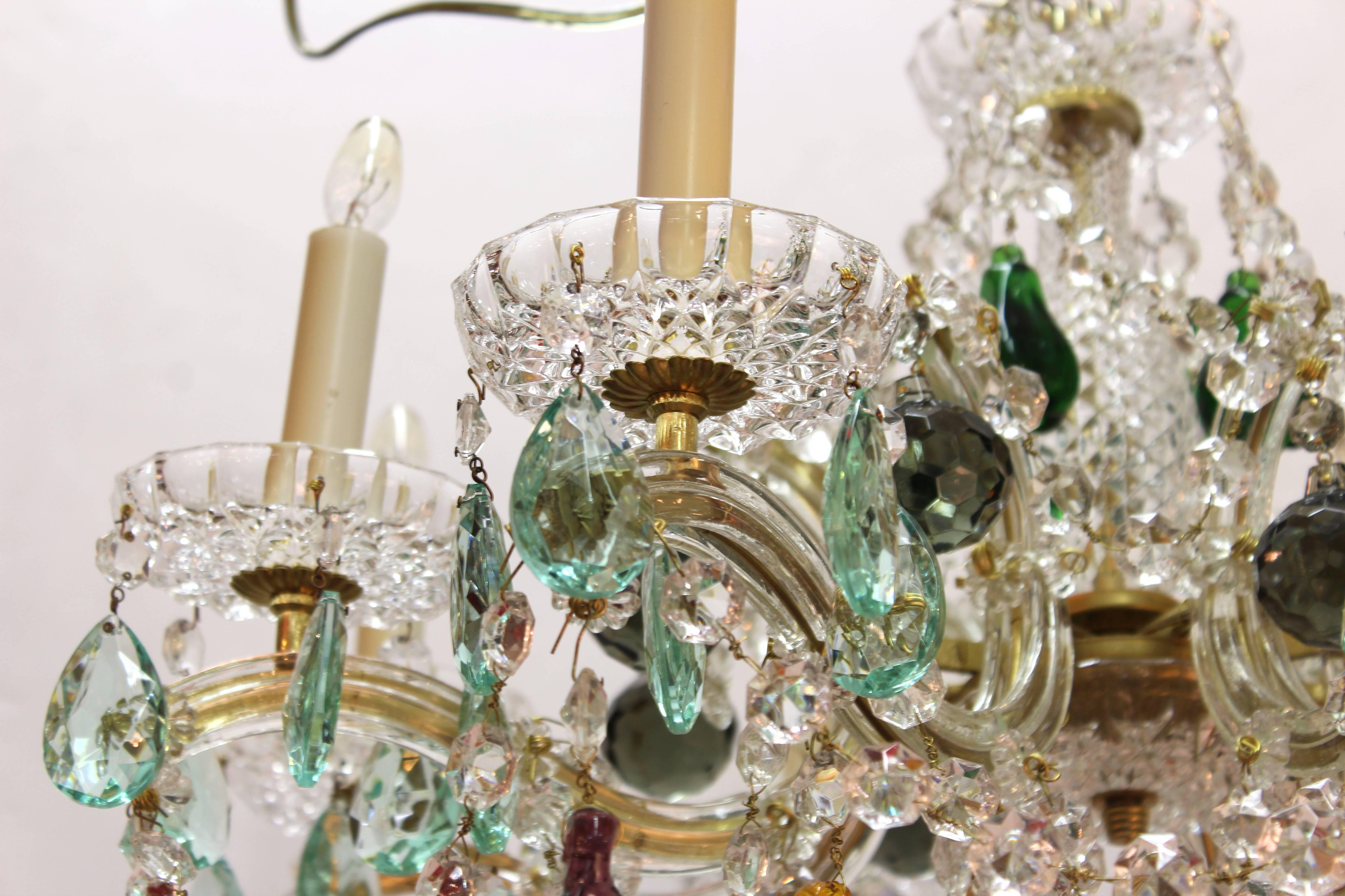 Maria Theresa chandelier from Italy dating from the mid-20th Century. Produced with eight arms decorated with clear and aqua crystals. Multi-colored crystal fruit dangle throughout. Wear appropriate to age and use. The chandelier is in excellent