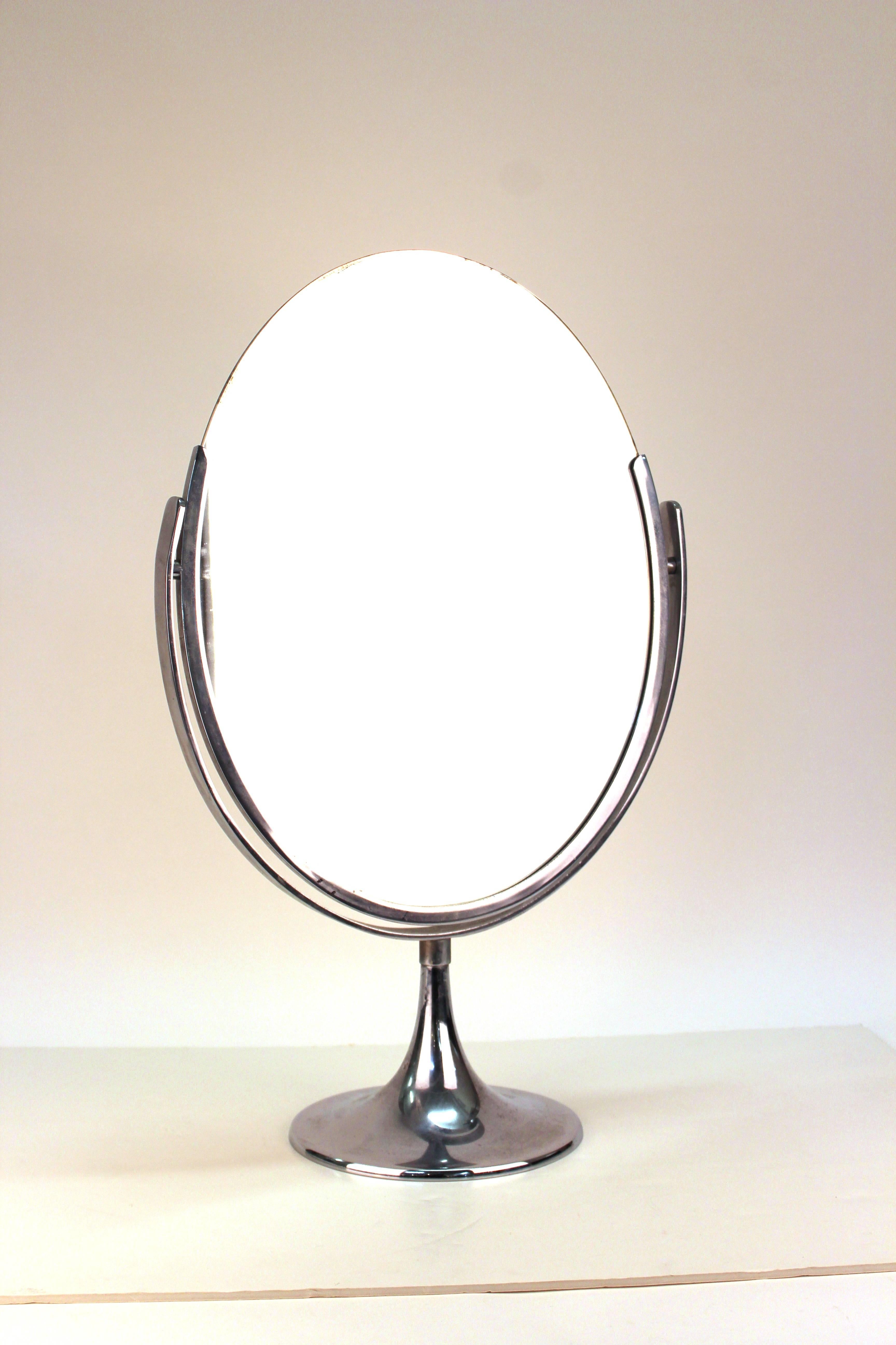 A Mid-century modern oval counter-top vanity mirror with a chrome base. The piece was made in the United States during the 1950's and is in great vintage condition.