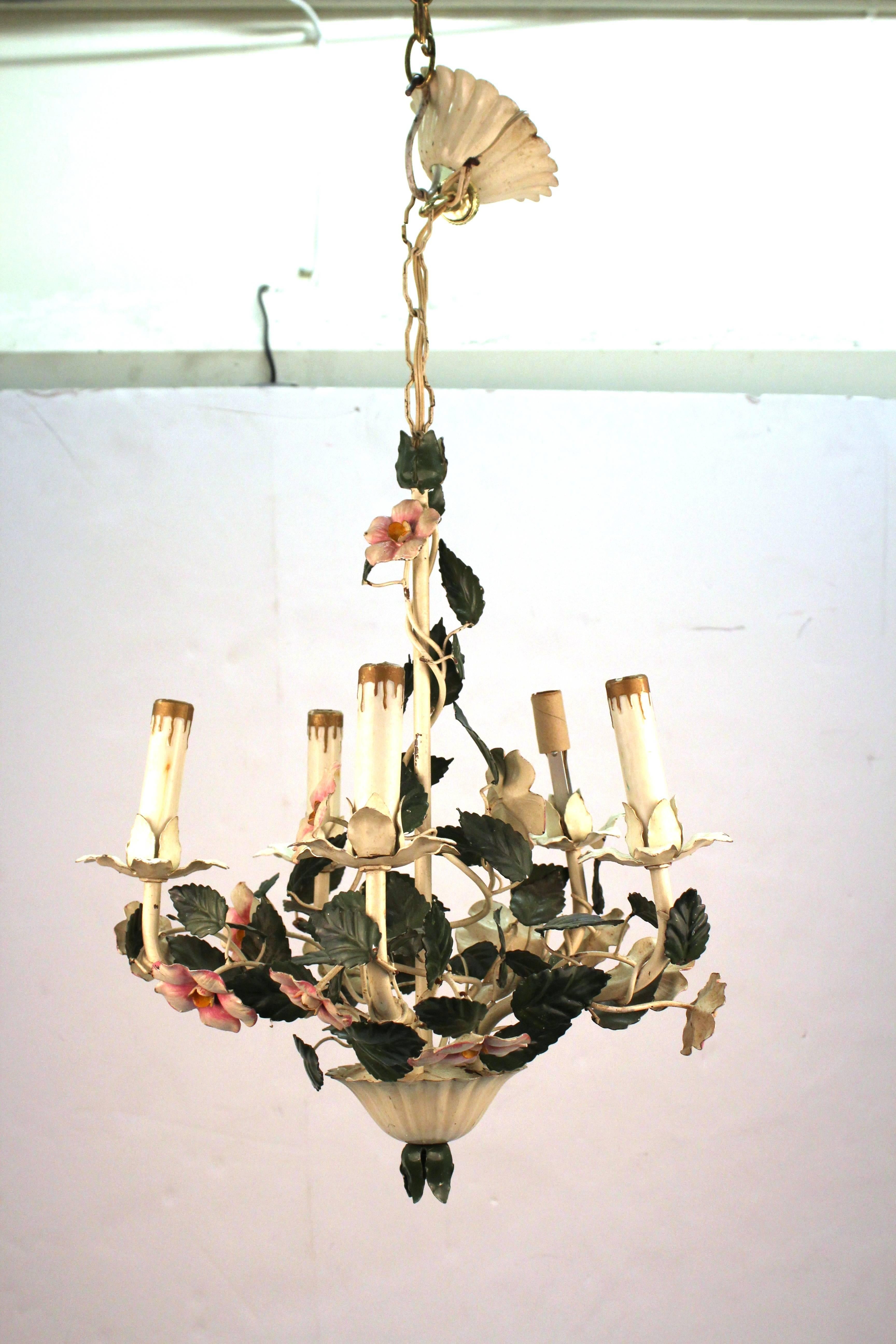 A Mid-century floral chandelier made in tole-ware. The chandelier has 5 arms and one of the light bulb holders is in need of replacement. The metal is in great vintage condition