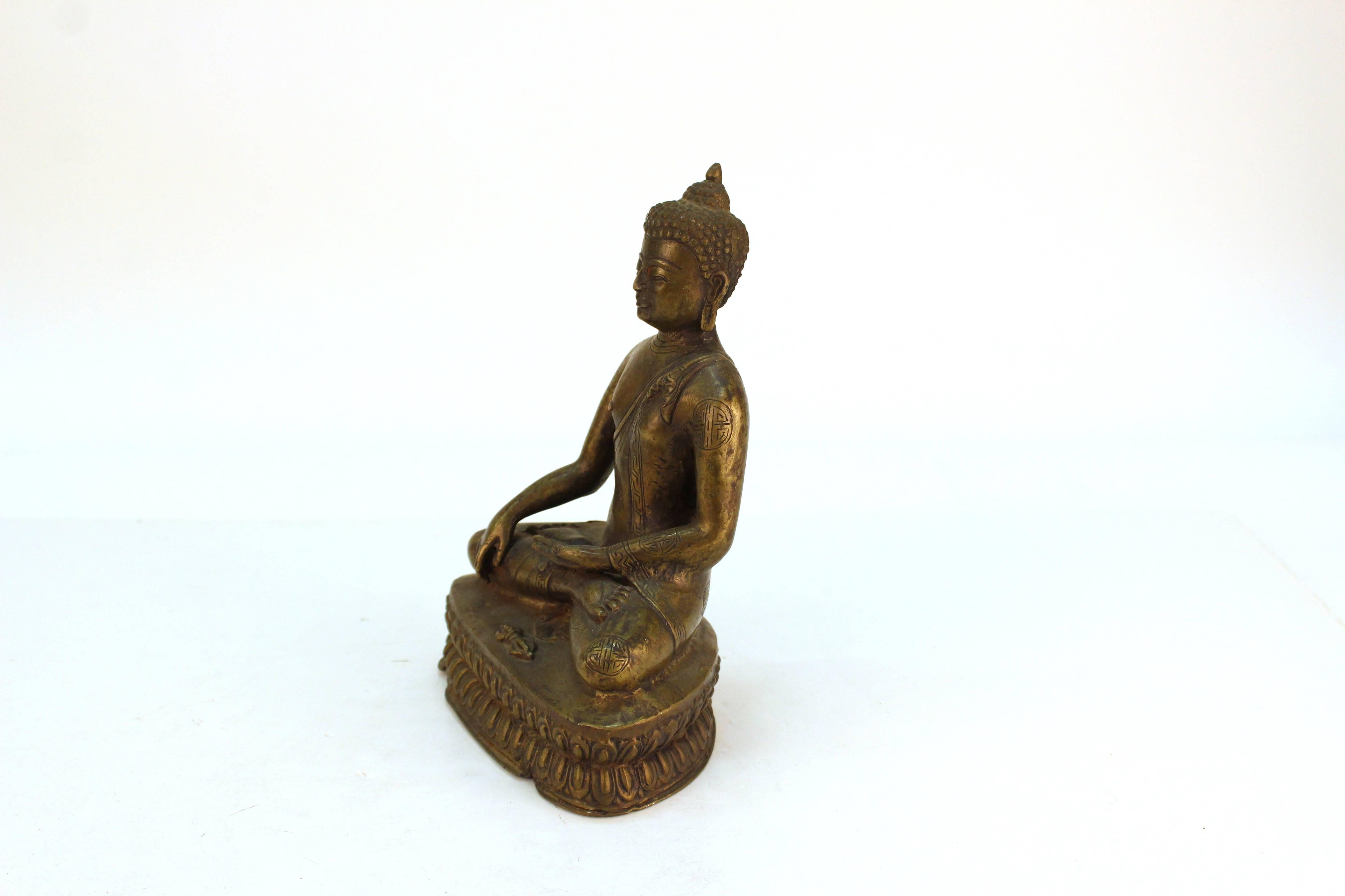 A Chinese bronze sculpture of a Buddha in a seated position. The piece is in great vintage condition.