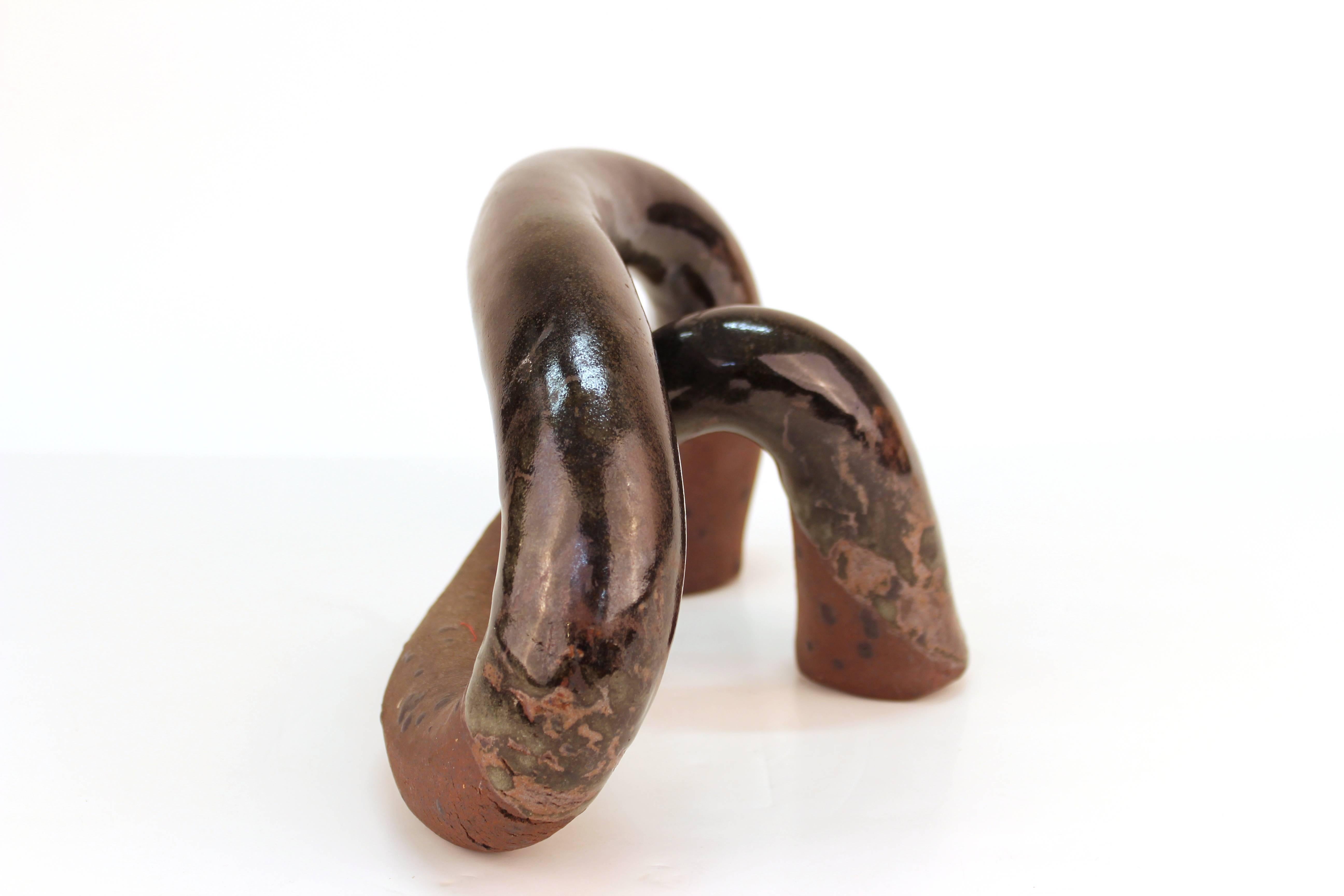 A Mid-century modern partly glazed black sculpture in an anthropomorphic shape. The piece has a mark on one if its feet and is in good vintage quality.