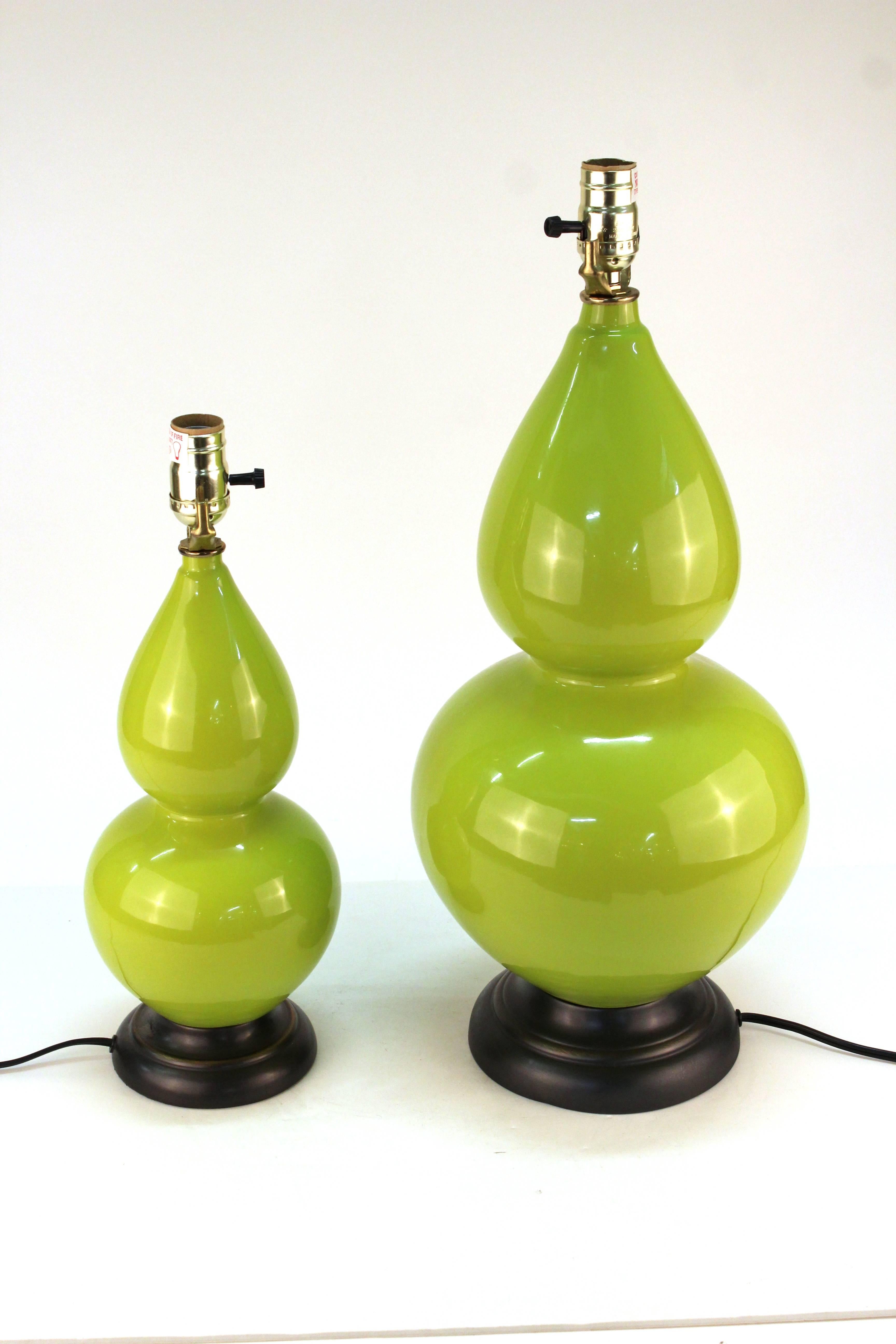 A pair of light green table lamps in two different sizes, in Hollywood Regency manner. Wired to US standards. In good vintage condition.