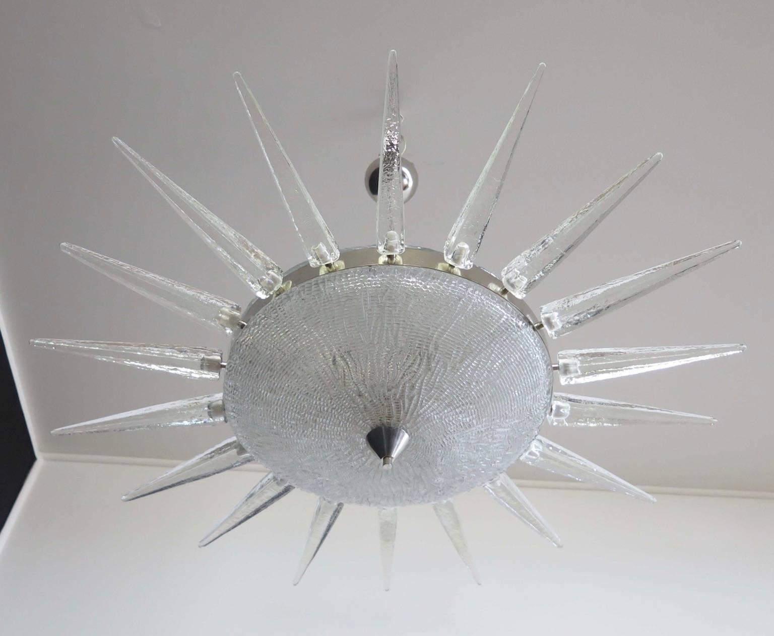 Sunburst-form Sputnik Murano glass chandelier in the style of Seguso from circa 2000 in a nickel frame surrounding central glass bowl and dome surrounded by 18 glass 'rays.' Each glass ray measures 11.8