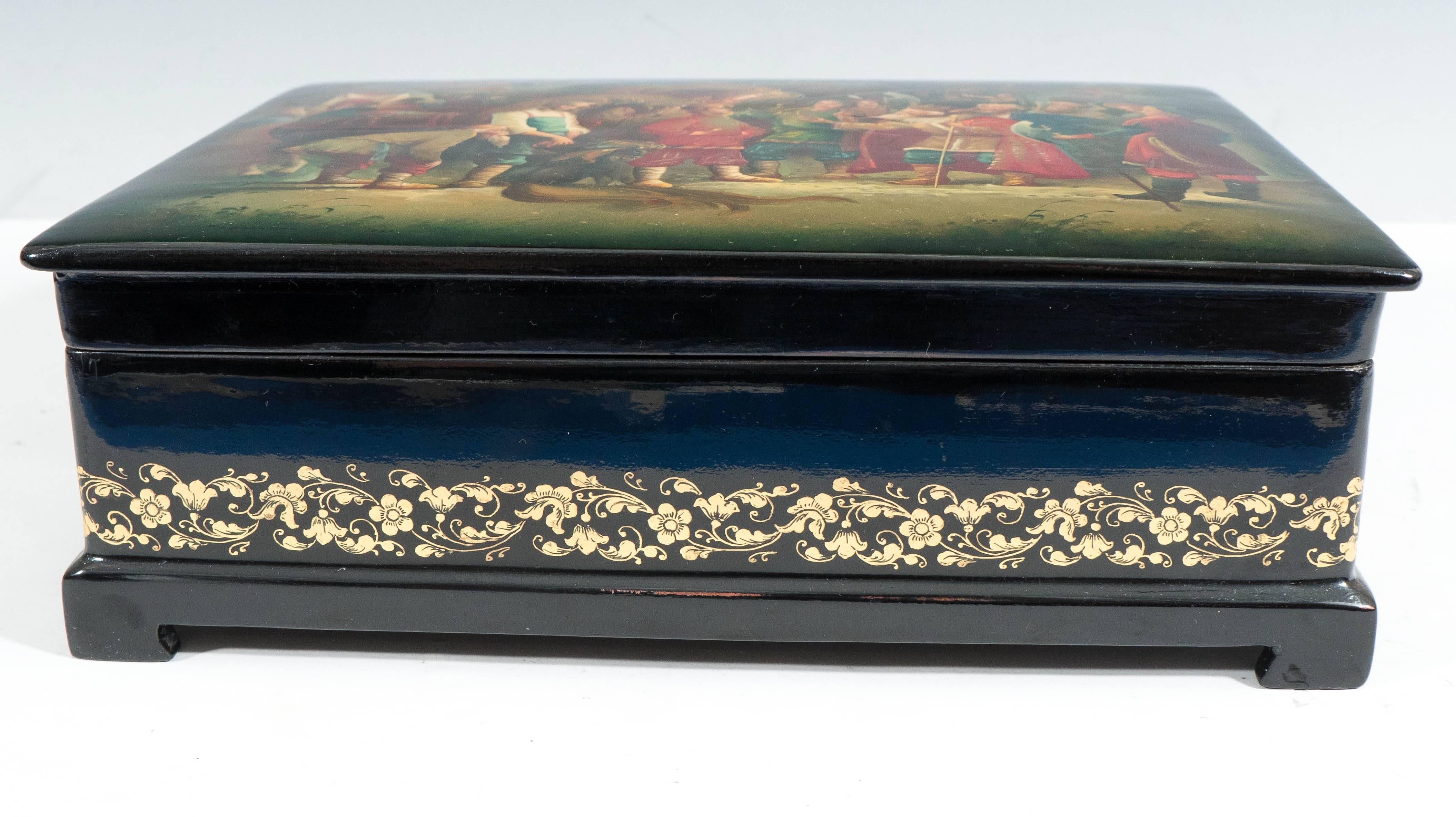 This exquisite Russian Fedoskino black lacquer box, with bright red interior, produced circa 1980s, depicts a vividly detailed scene from the much adapted fairy tale 'The Little Humpbacked Horse' ('Konyok-Gorbunok'). The historic village of