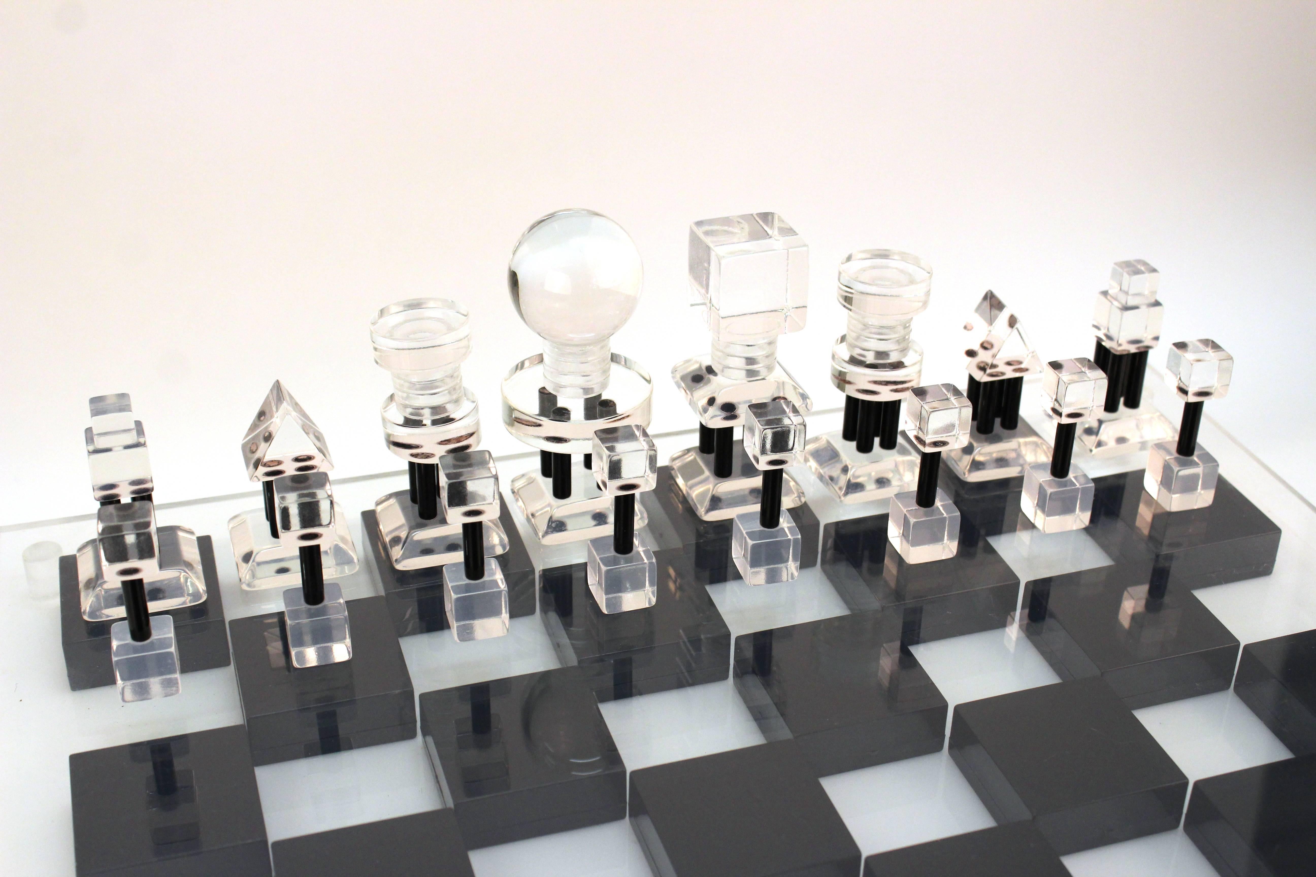 A large Mid-Century Modern Lucite black, white and clear chess set with elaborate chess pieces and a clear Lucite cover. Very rare and heavy piece, made in the 1960s in the United States. In excellent condition.
