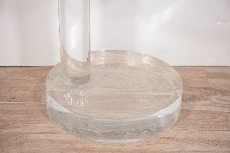 A vintage end or side table, produced circa 1970s with round glass top, inset by a single cylindrical column on a circular base, entirely in Lucite. Very good condition, with age appropriate wear.