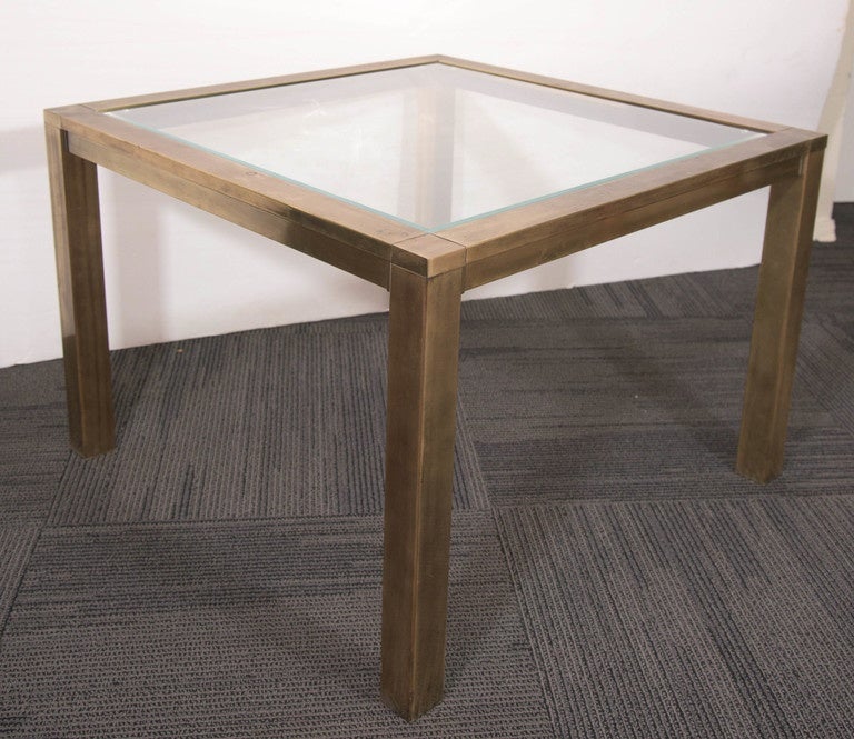 A vintage side and end table, produced circa 1970s by Mastercraft, with highly modernistic brass frame, inset with glass top, on rectangular legs. Good condition, with age appropriate wear and nice patina to the brass, including some minor scuffs to