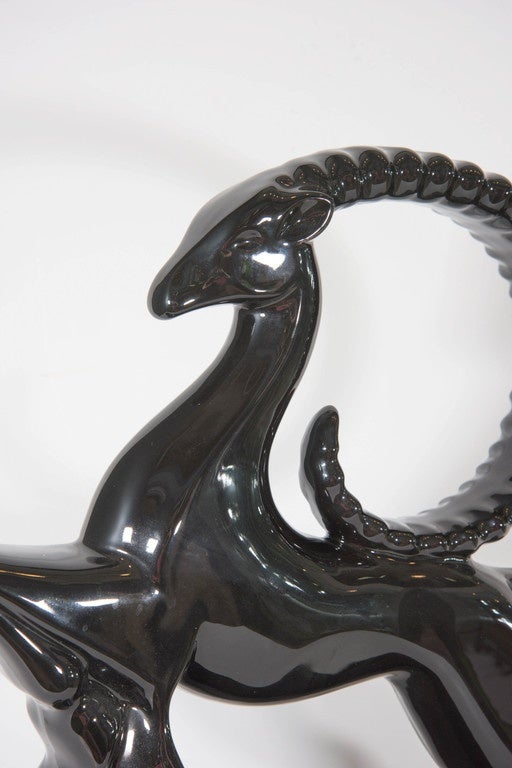 A vintage Art Deco sculpture of an elegant black gazelle in mid-leap, produced by Royal Haeger, circa 1940s-1950s, in glazed ceramic. Markings include original label [Haeger/American Made], on the underside base of the sculpture. Very good vintage