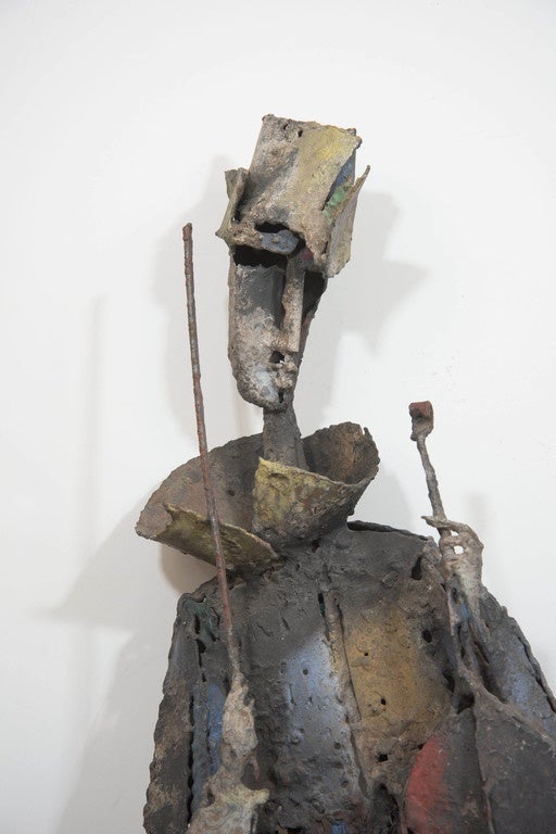 A Cubist wall sculpture, produced circa 1950s by American artist Robert E. Kuhn (1917-2000), which depicts the abstracted figure of a musician with violin, pausing between playing, in welded and hand-painted wrought iron. Markings include the