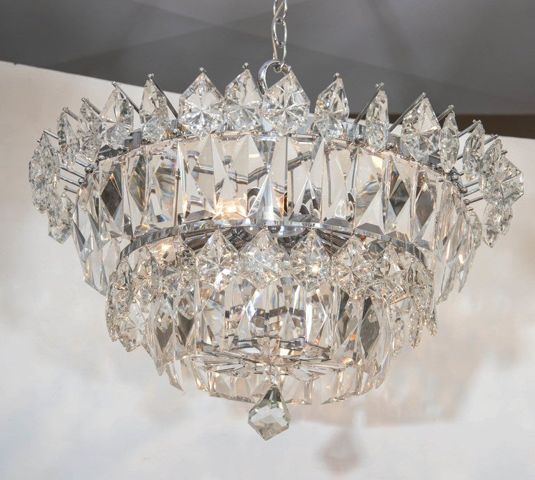 A vintage Italian chandelier, produced circa 1960s, with surrounding Murano cut crystal rectangular beveled panels and suspended hexagonal prisms, affixed to four circular metal frames, terminating with a faceted crystal drop. Wiring and sockets to