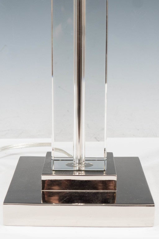A pair of highly modernistic table lamps, produced, circa 1970s-1980s, in the style of T.H. Robsjohn-Gibbings, with rectangular form Lucite stem, on steeped, chrome-plated square base; harp with cube finial included. Wiring and sockets to US