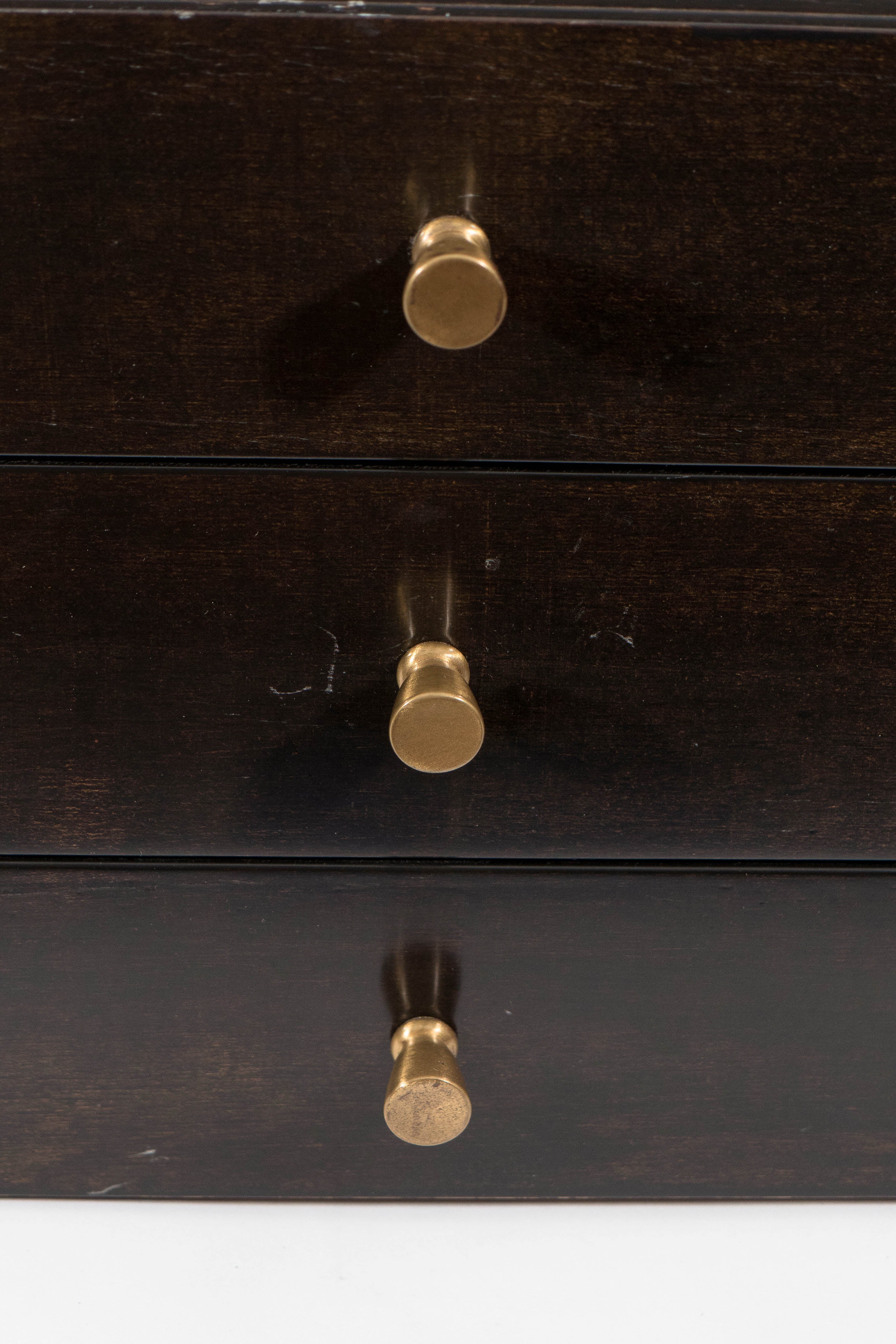 A vintage jewelry chest, designed by Paul McCobb for the Calvin Group-Irwin Collection, circa 1950's, in mahogany, with the three exterior drawers and brass knob pulls. Markings include original maker's label, inside the top drawer. Good vintage